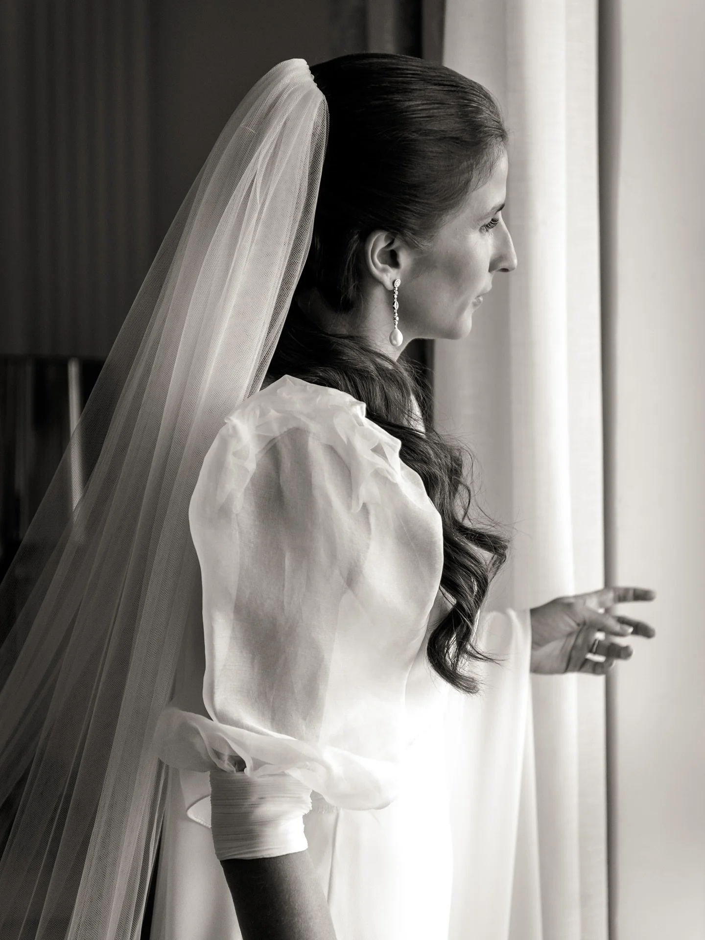 En esta imagen, Paula S&aacute;nchez se prepara para uno de los momentos m&aacute;s importantes de su vida. La luz que entra por la ventana acaricia suavemente su rostro, reflejando la serenidad y la ilusi&oacute;n que la acompa&ntilde;an en este d&i