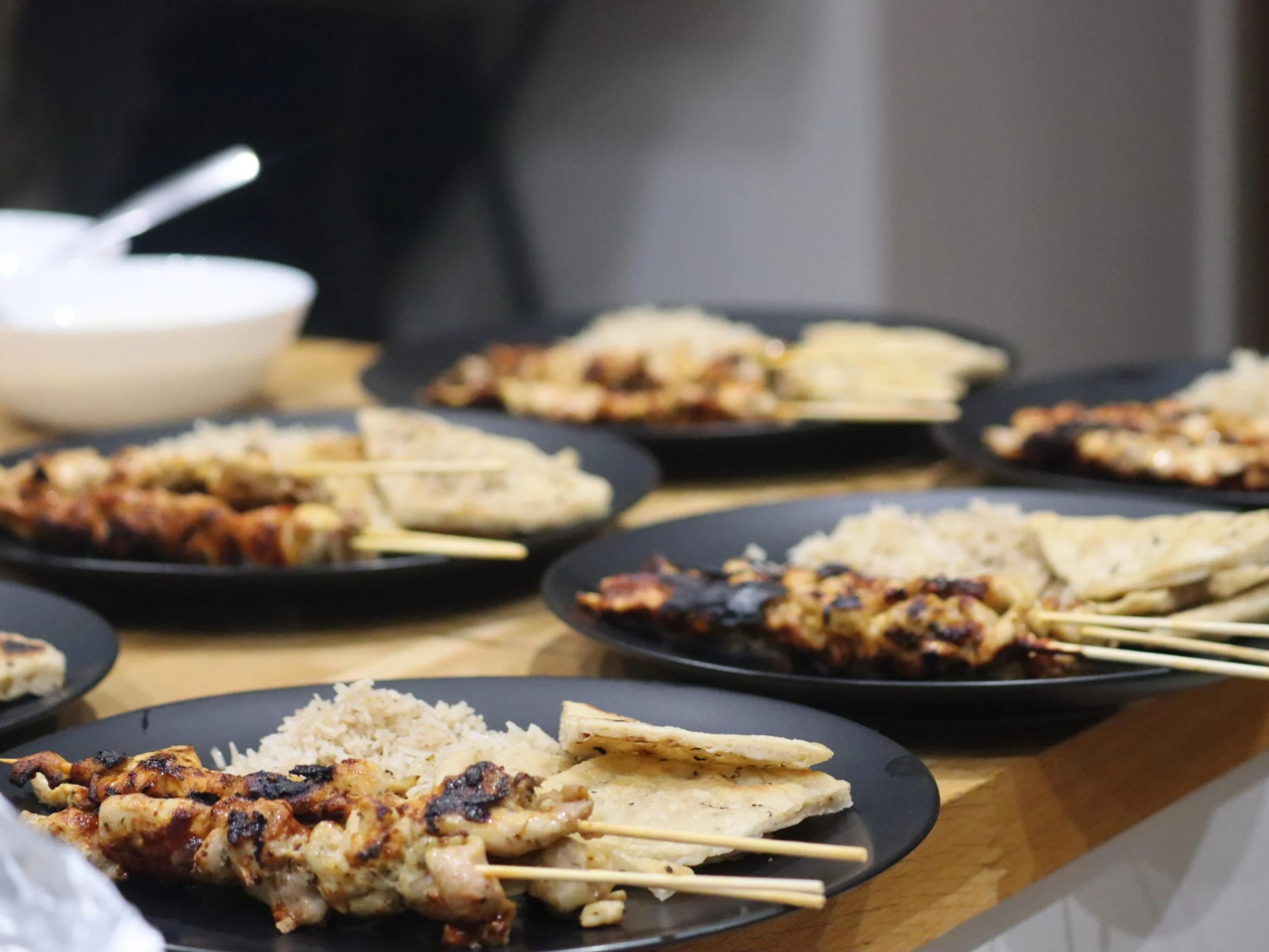 Greek chicken souvlaki skewers served with seasoned rice and warm pita bread.