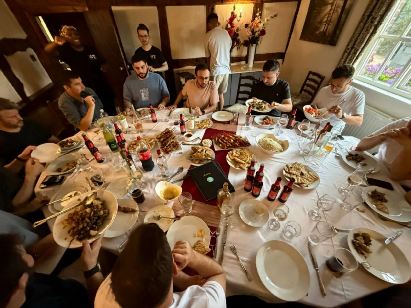 Guests seated around a table enjoying Greek Tings sharing dishes at a private event.
