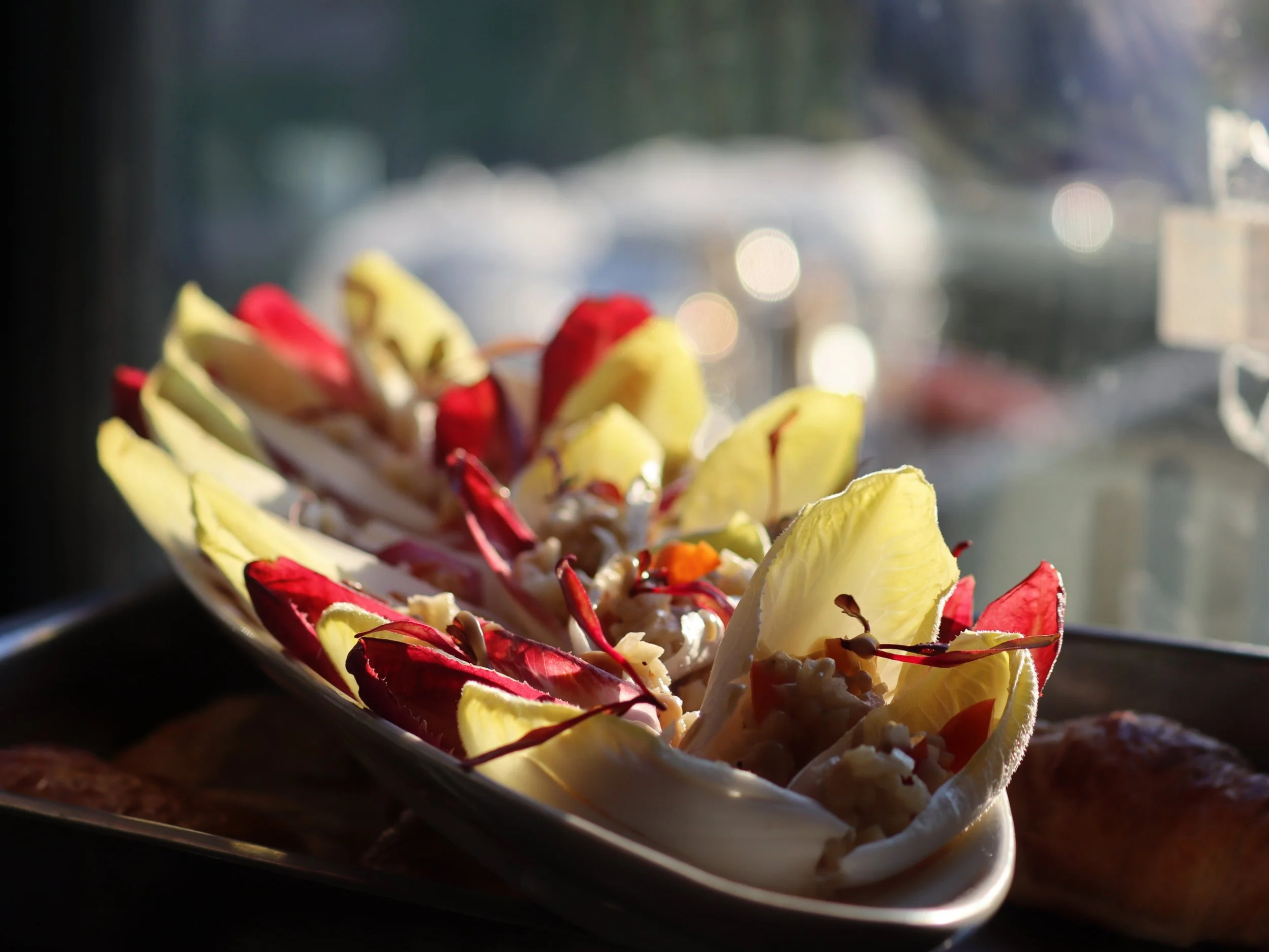 Chicory leaf canapés filled with a savoury grain mixture and topped with microgreens.
