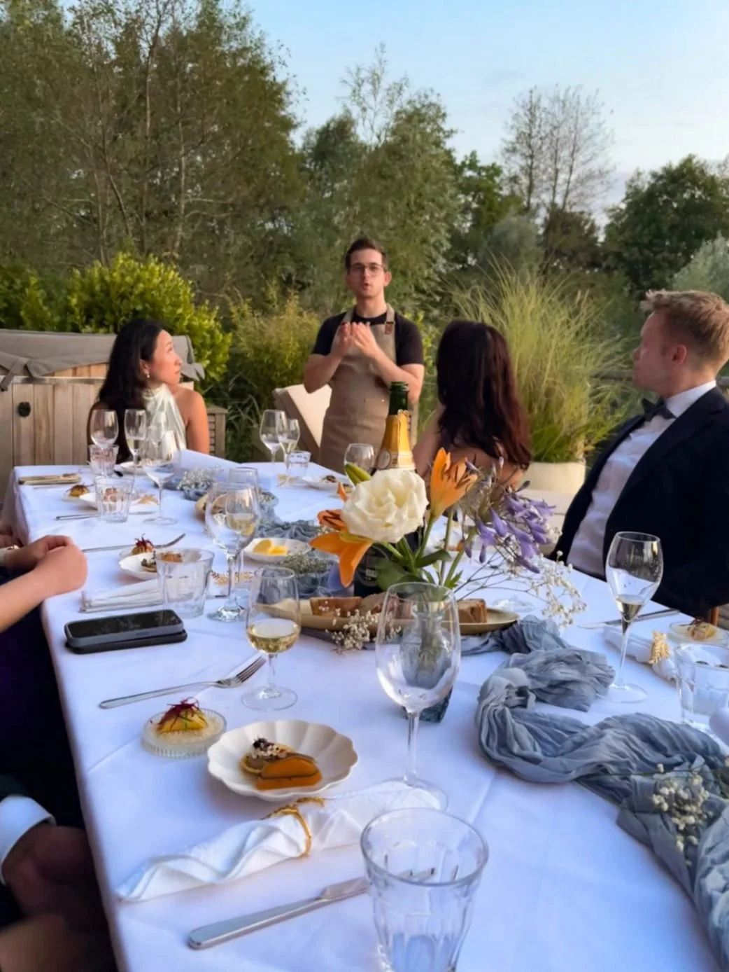 Chef talking to guests, fine dining evening, late summer, table filled with canapés, floral centrepiece, dining, private chef,