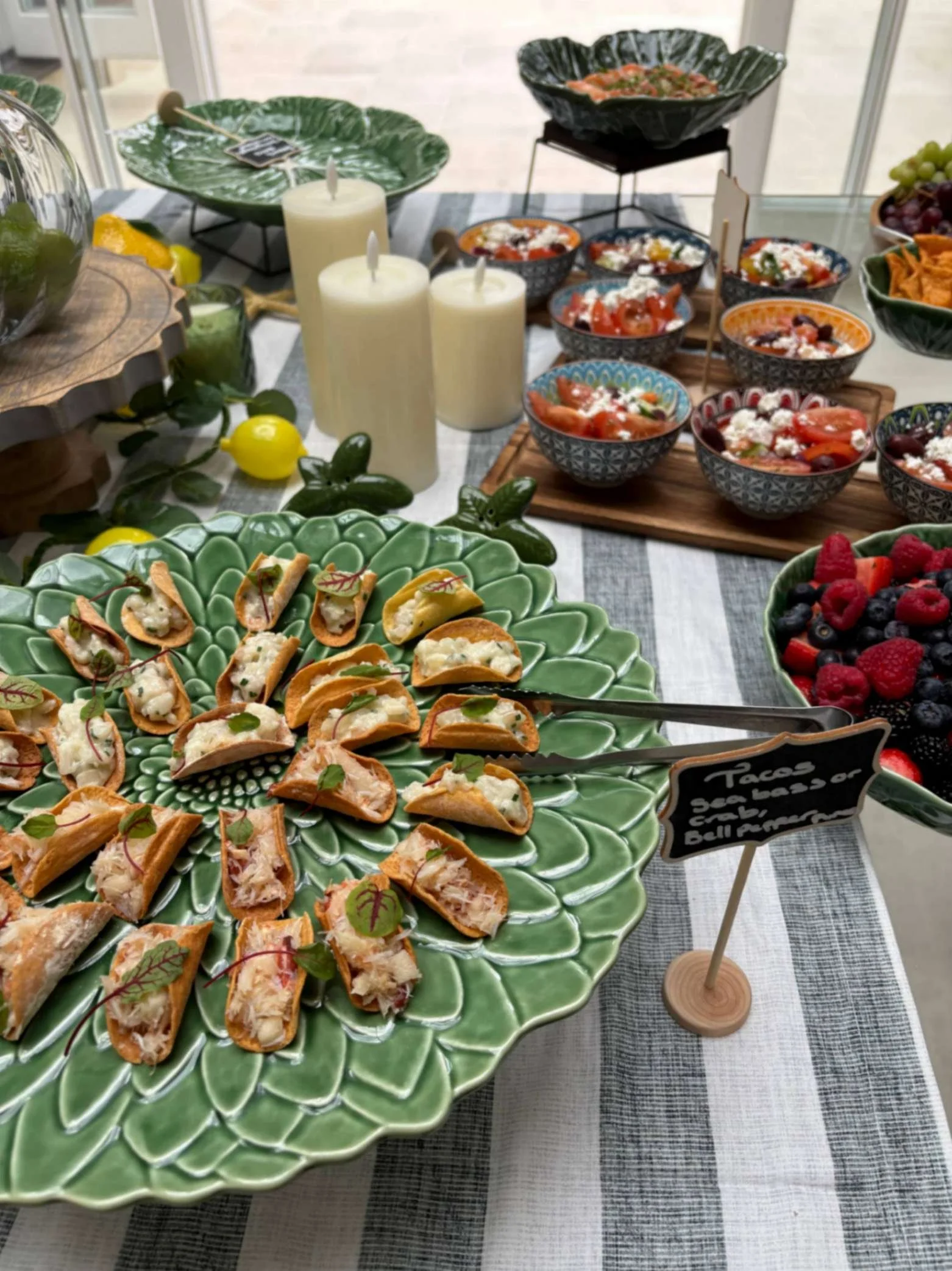 Colourful canapé table with savoury tartlets, feta salads, fruit and Greek-Jamaican fusion bites.