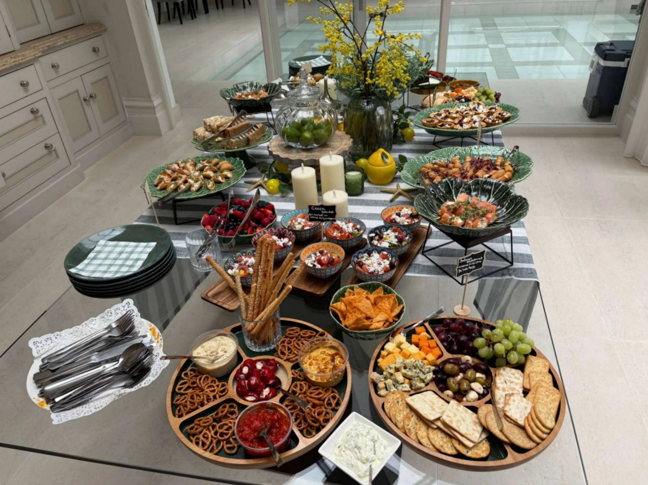 Large Greek Tings grazing table with canapés, salads, fruit, cheeses, crackers, dips and sharing dishes.