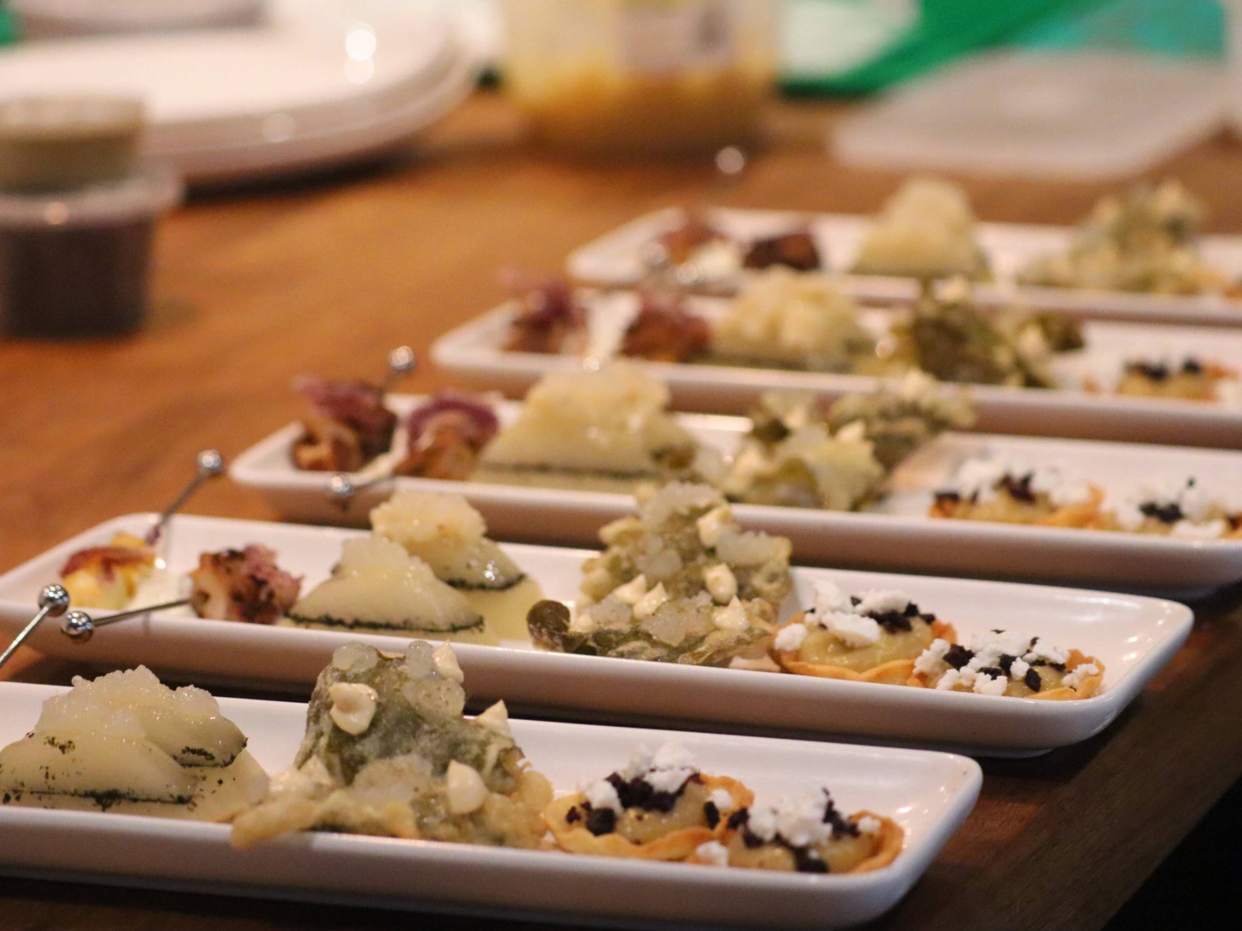 Assorted fine dining canapés plated in rows for a multi-course private dining experience