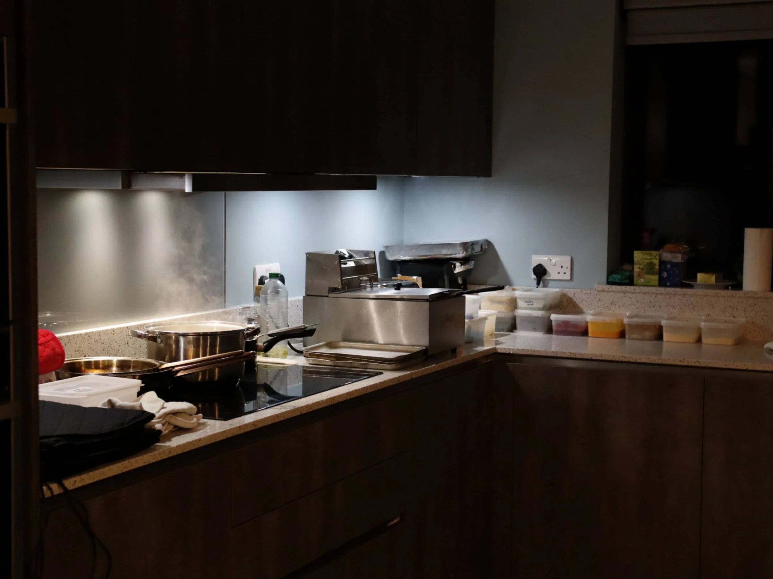 Temporary private chef kitchen station with pans and prepared ingredients before service.
