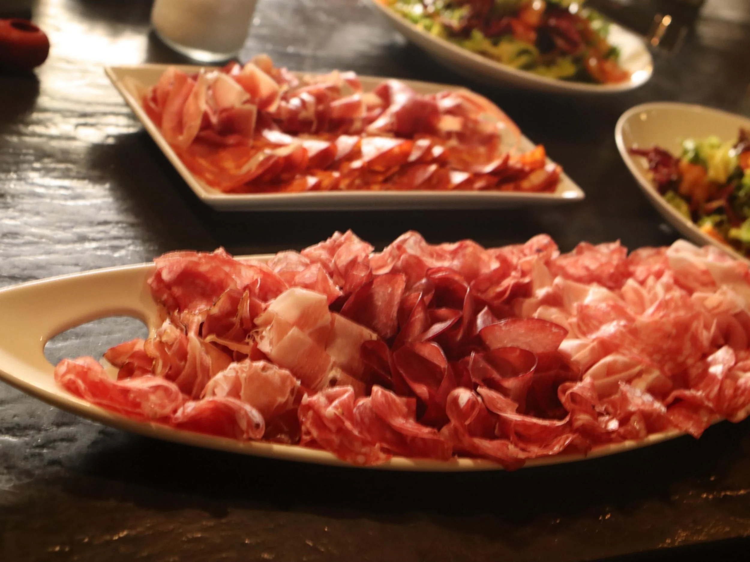 Italian charcuterie platters with assorted cured meats for sharing.
