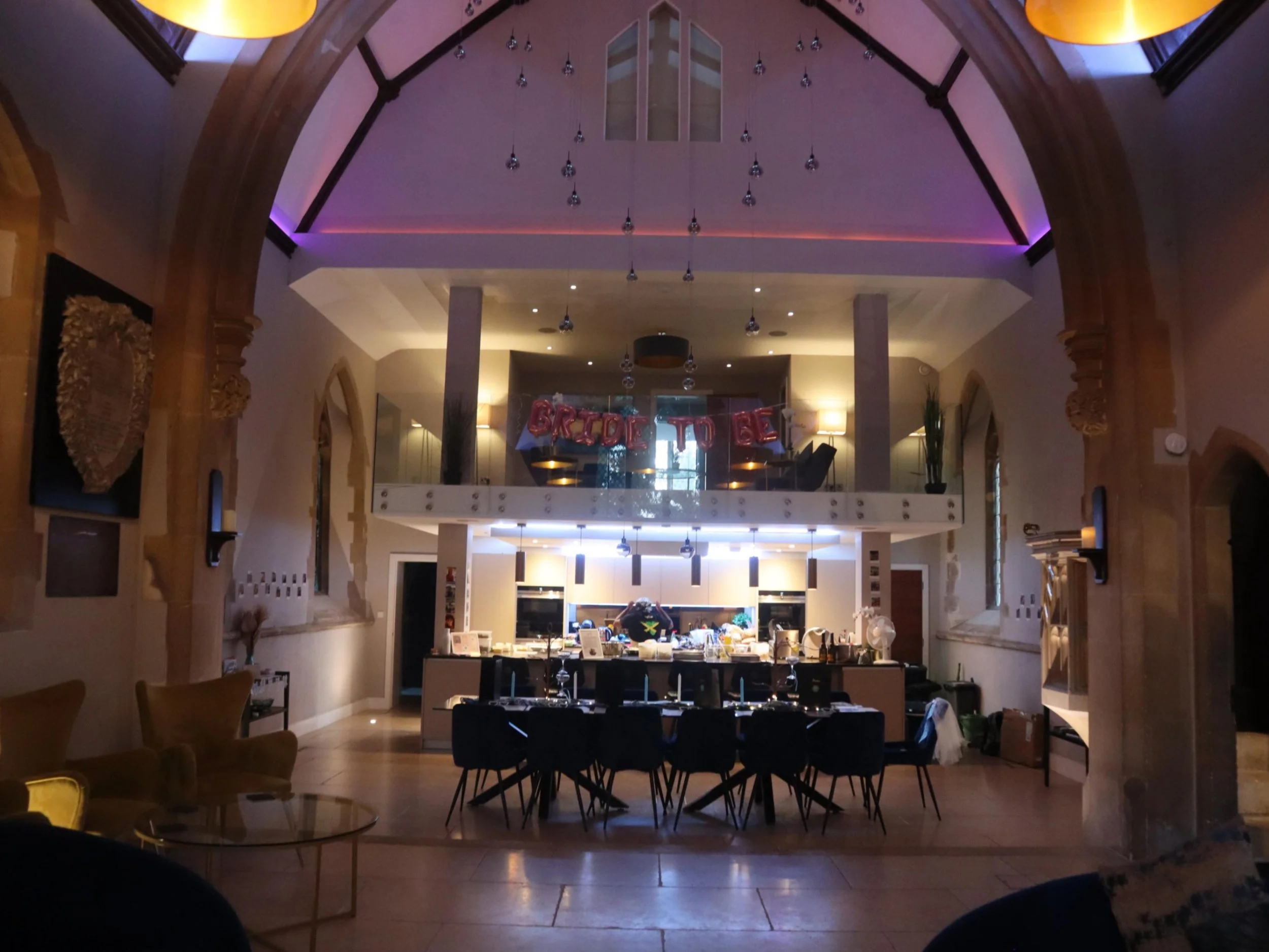 Large private event venue in a converted chapel with dining tables and celebration decorations.
