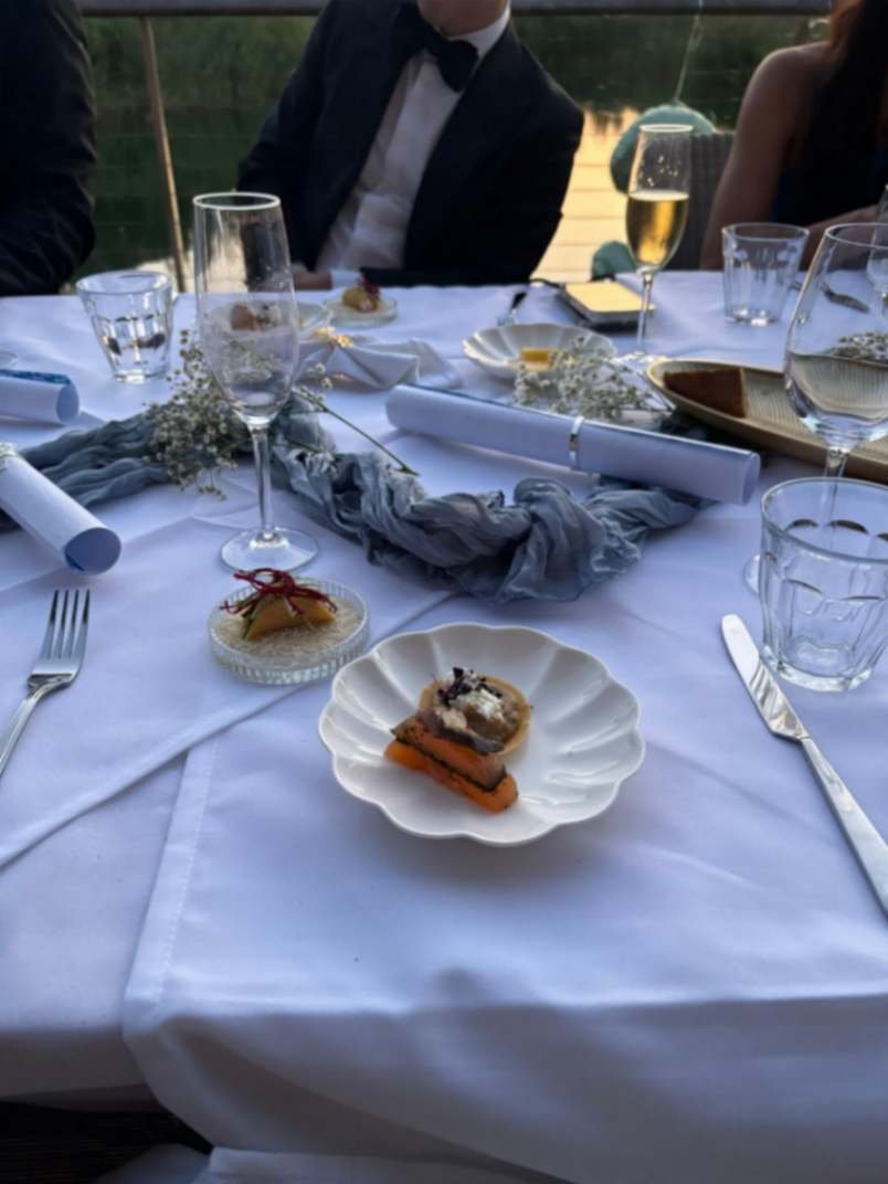 Individual canapés served at a formal private event table with guests and glassware.
