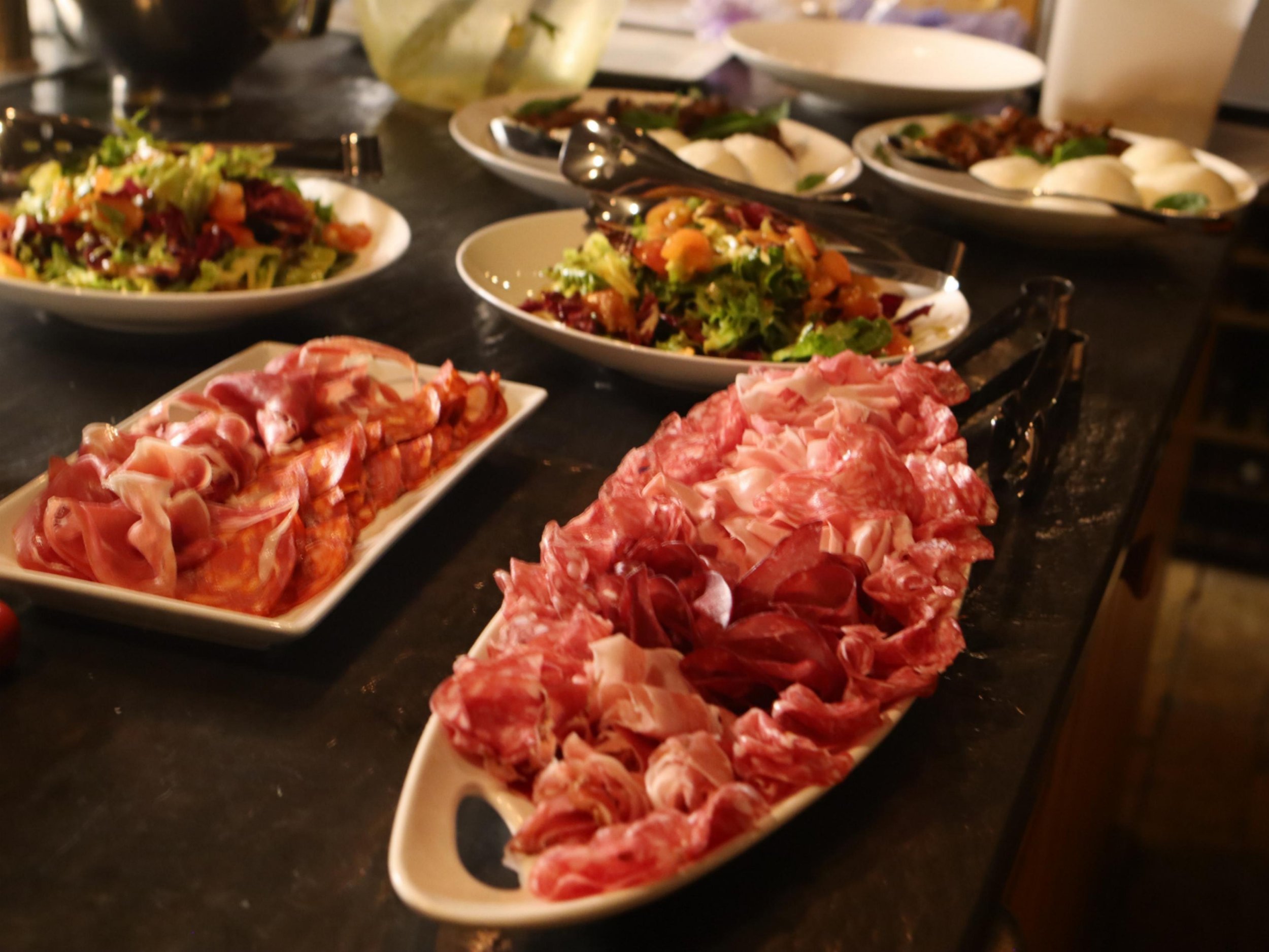 Italian antipasti spread with cured meats, salads, burrata and sharing dishes.
