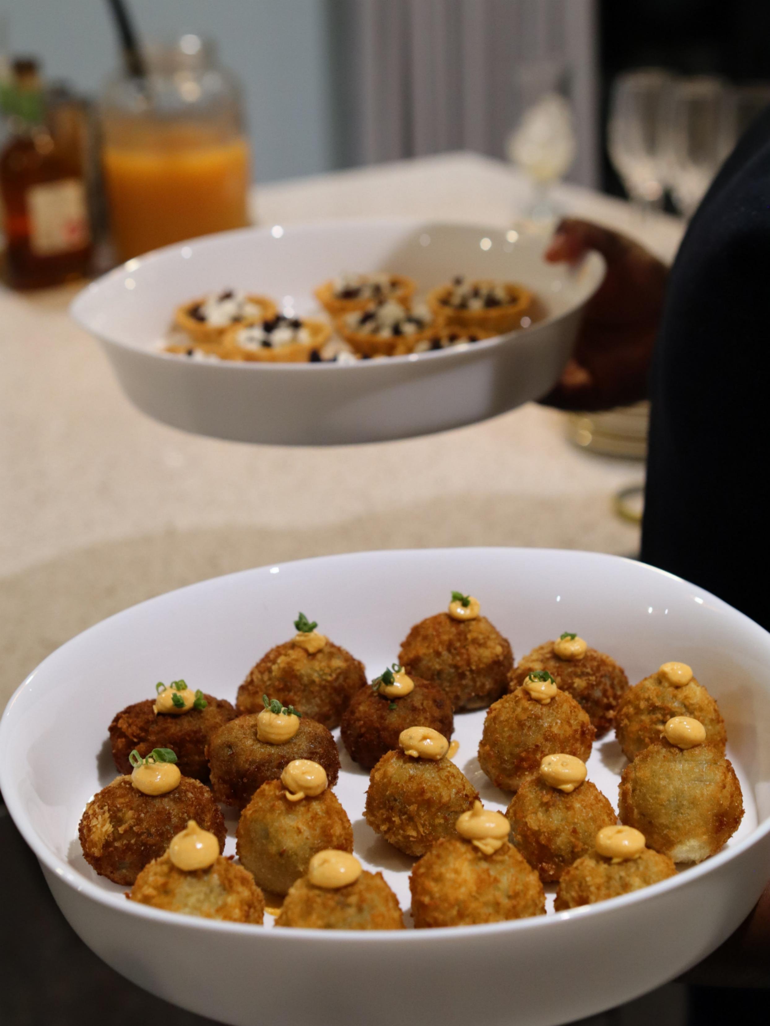 Golden fusion croquettes topped with spiced sauce and herbs, served as canapés by Greek Tings.