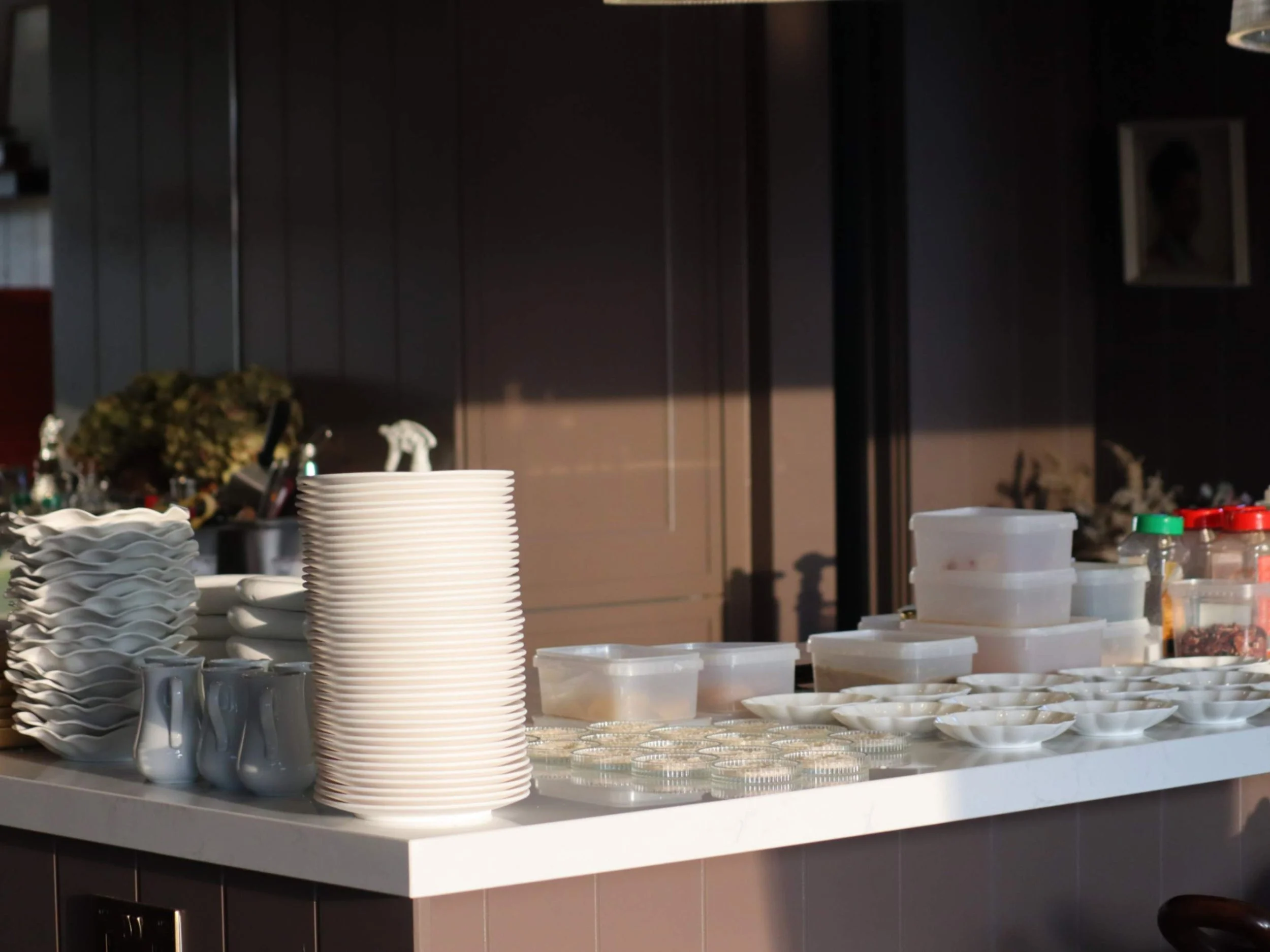 Organised private chef kitchen with stacked plates and prepared ingredients ready for service.
