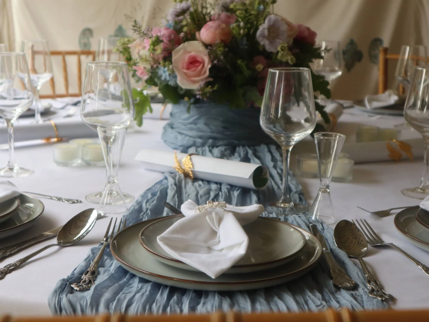 Elegant event table with blue runner, pink floral centrepiece and formal place settings by Greek Tings.