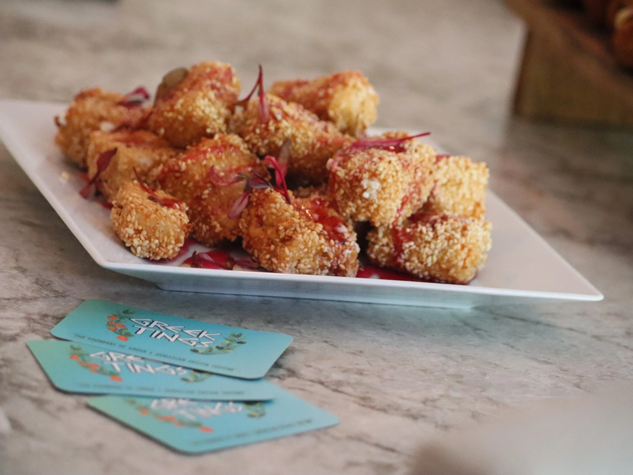 Golden coconut and sesame-crusted feta finished with Greek honey and raspberry syrup.