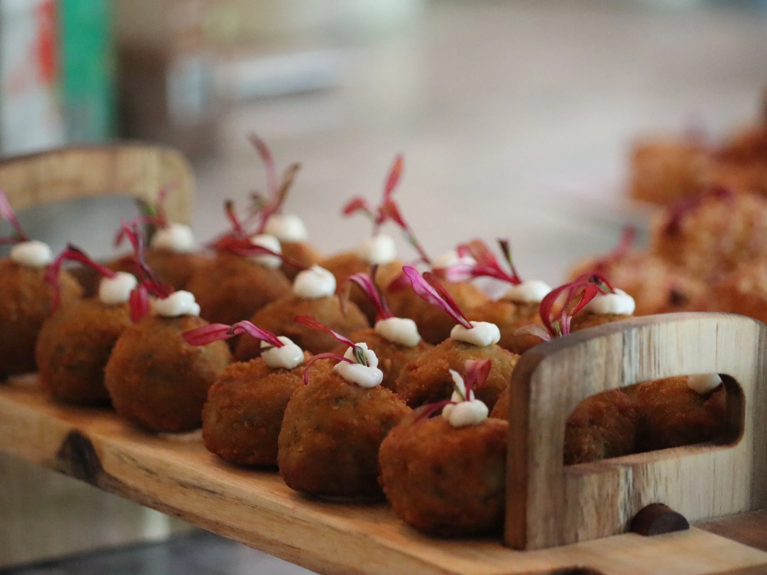 Golden fusion potato croquettes topped with creamy sauce and fresh herbs