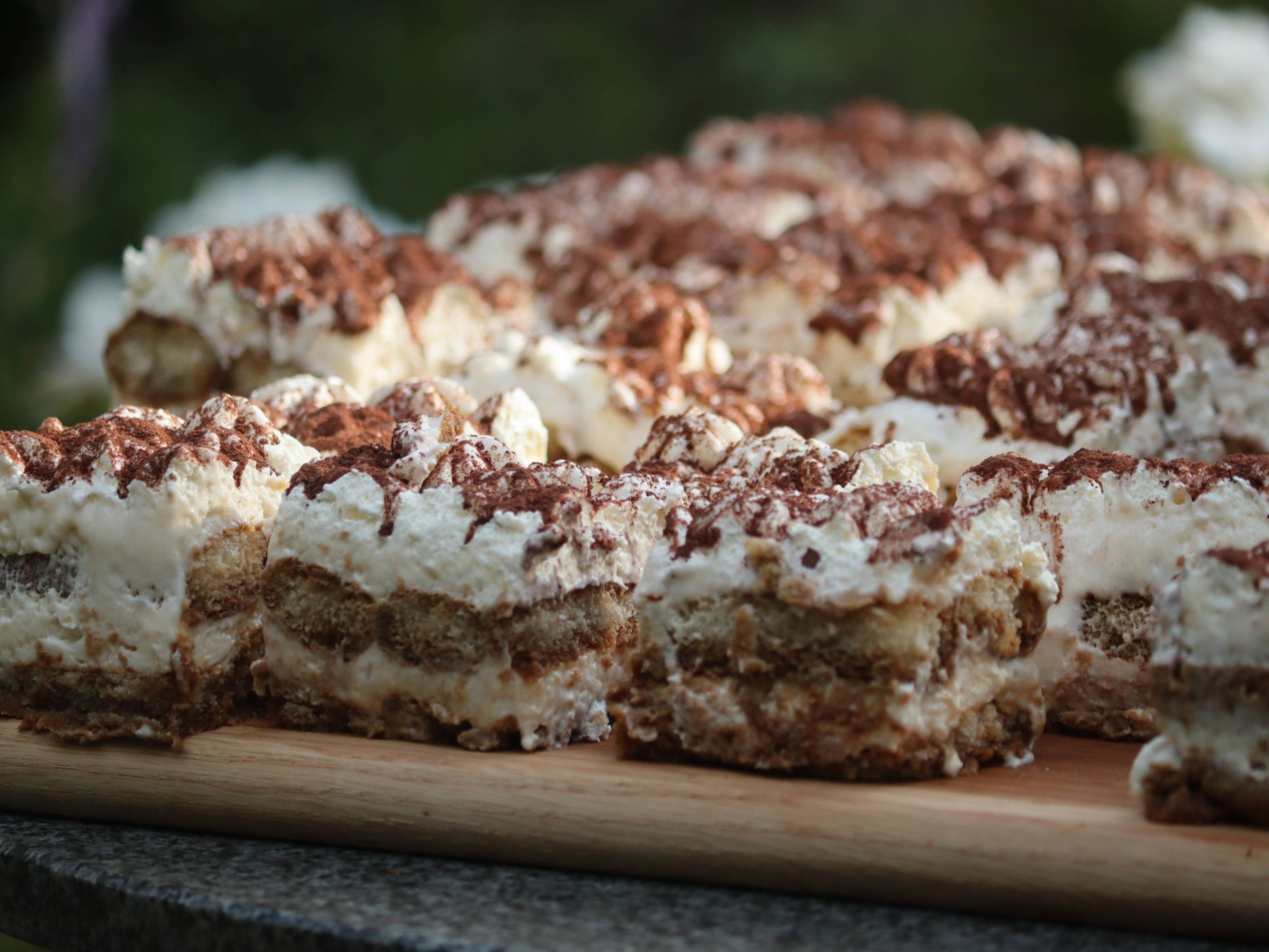 Freshly cut tiramisu portions arranged on a wooden board.