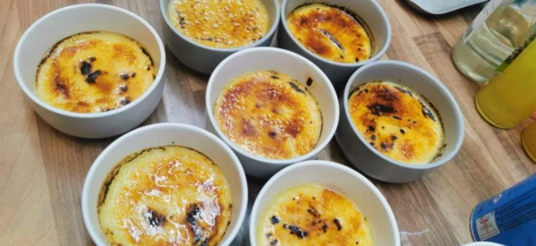 Individual crème brûlée ramekins with caramelised sugar tops ready for dessert service.