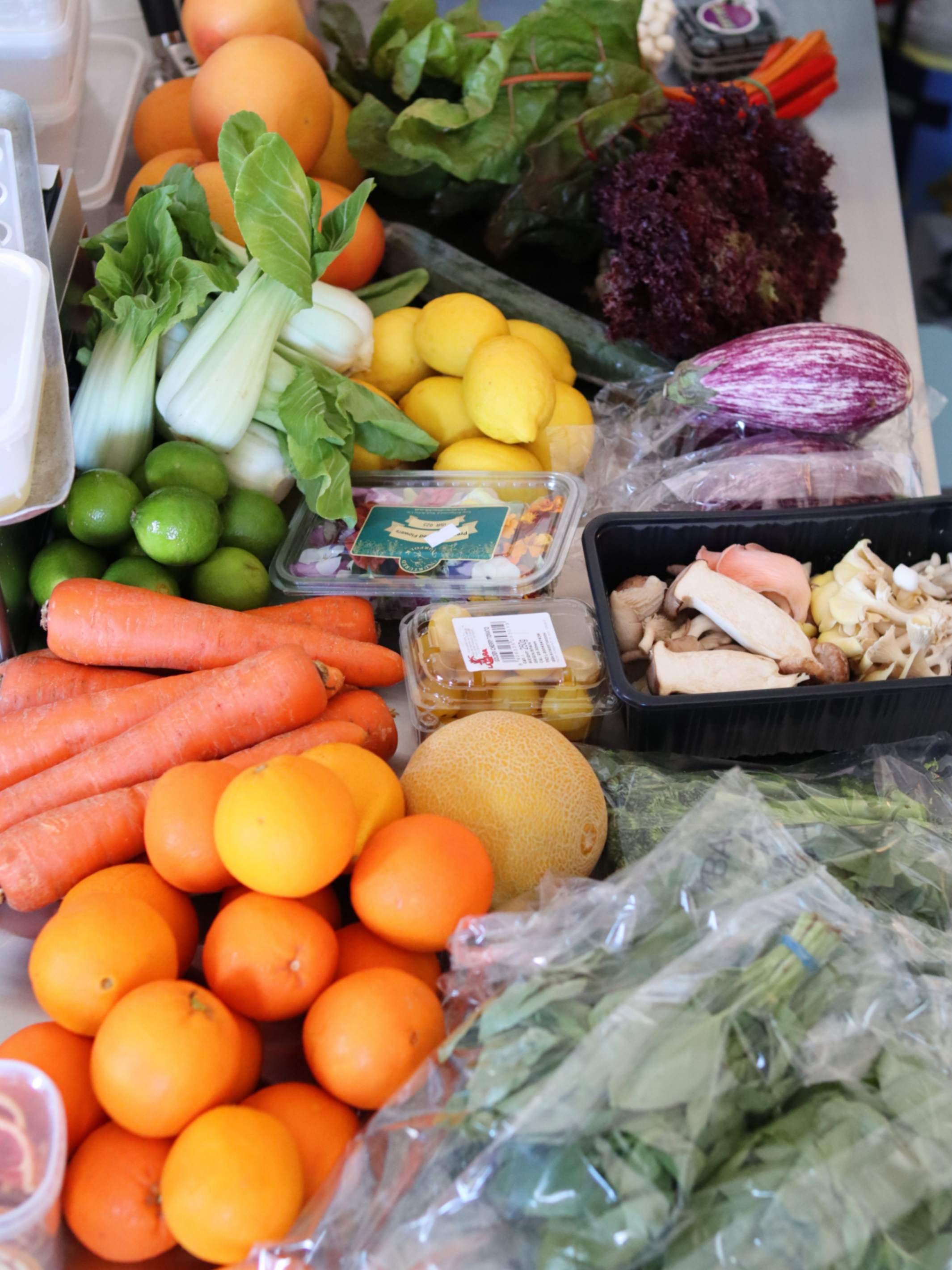 Fresh citrus, carrots, greens, mushrooms and vegetables prepared for a Greek Tings event.
