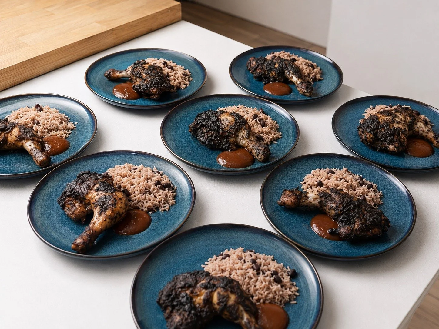 Jerk chicken served with rice and peas and sauce, plated for a Greek Tings Jamaican catering event.