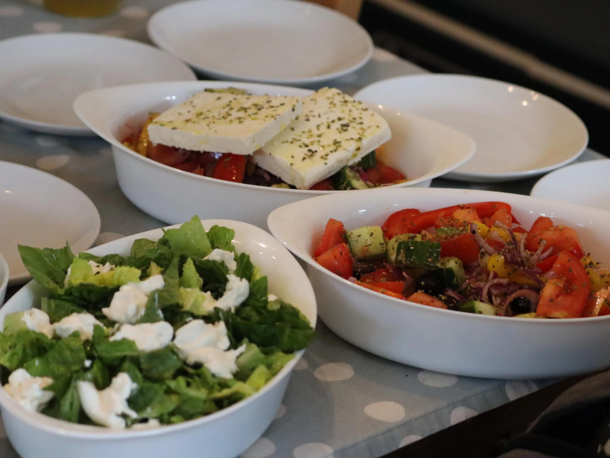 Greek-style salads with tomatoes, cucumber, olives, leafy greens and generous feta.