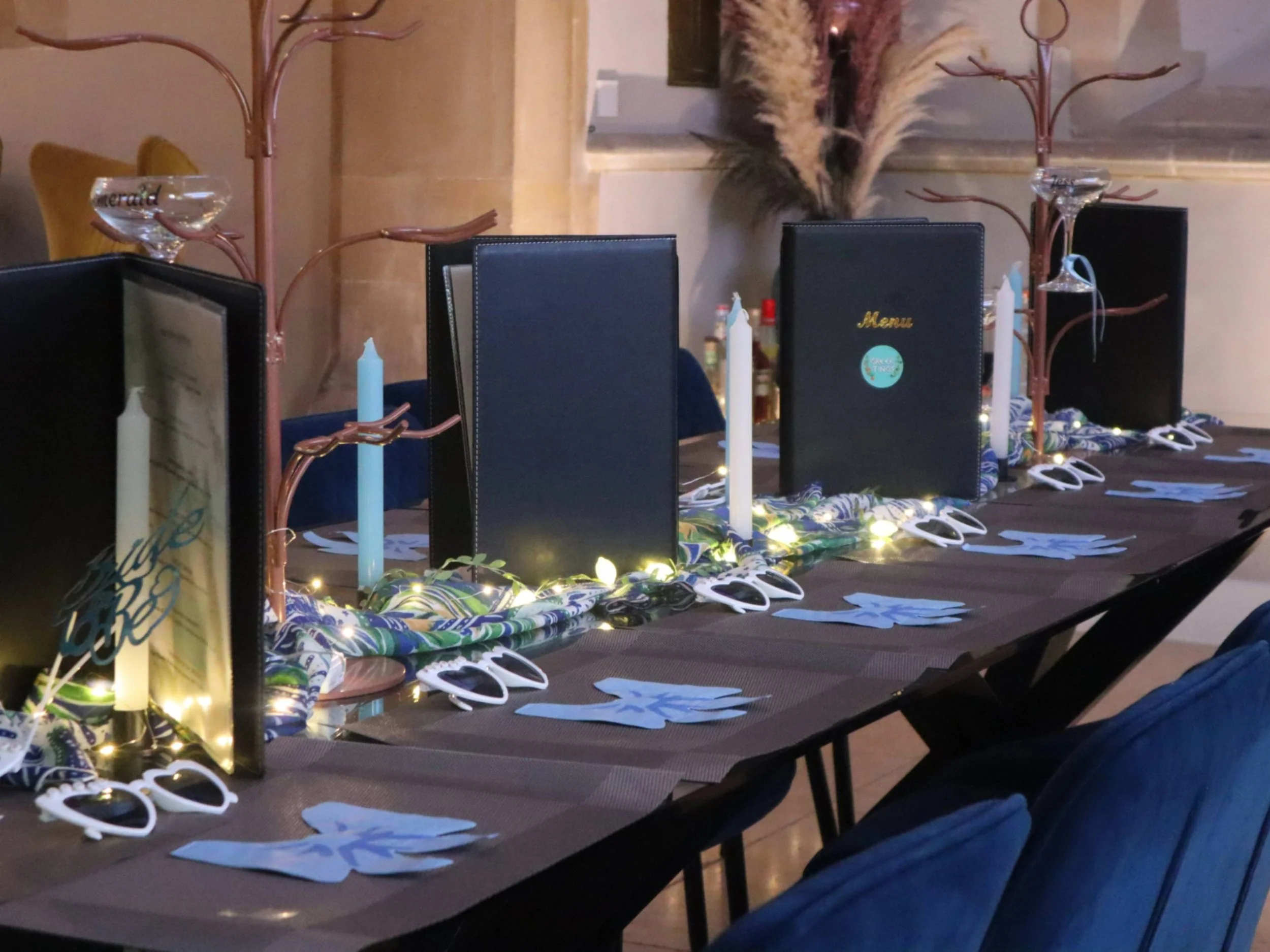 Themed private dining table with menus, candles, decorative napkins and playful table accessories.