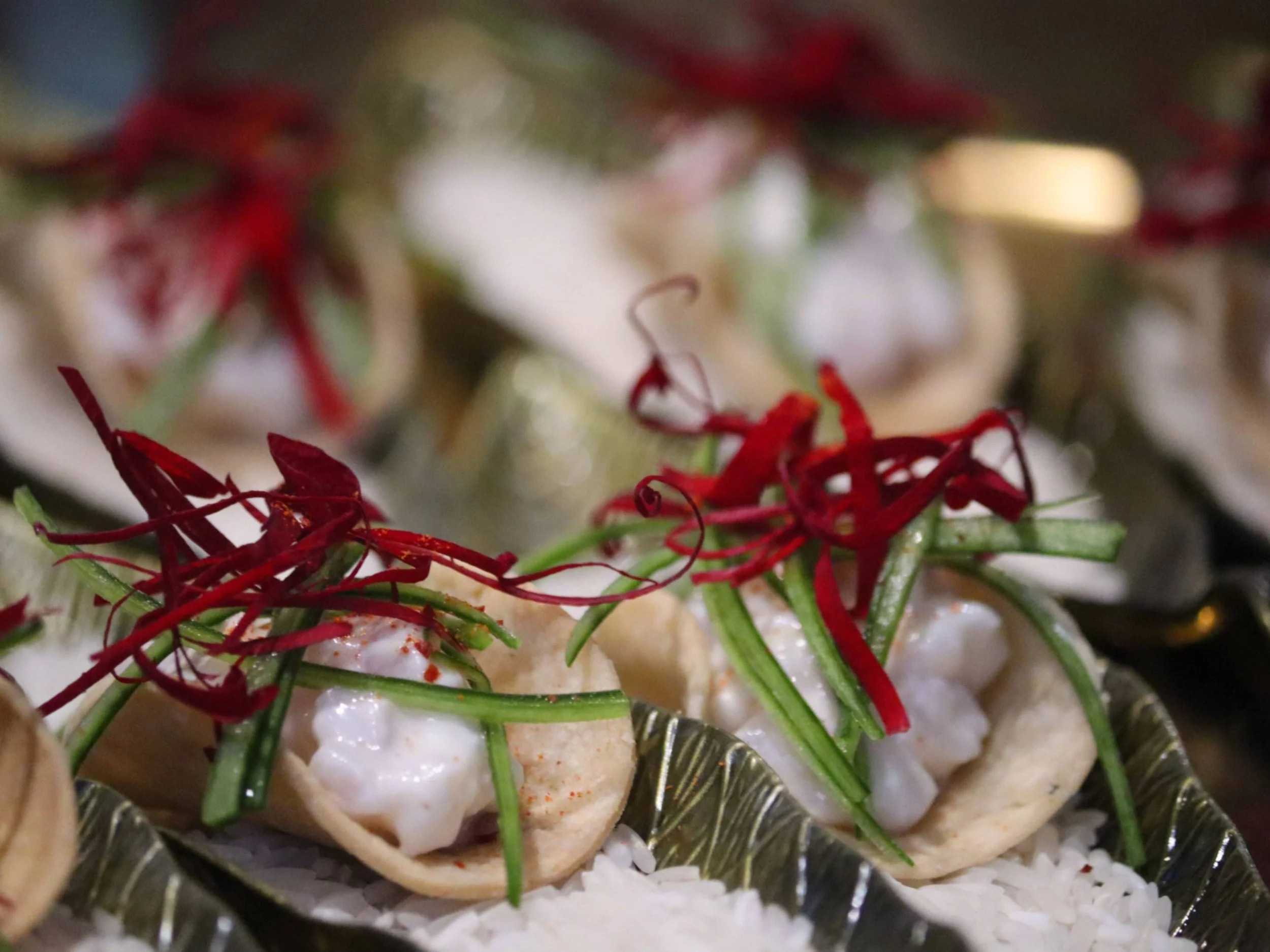 Mini fine dining tacos with creamy filling, cucumber ribbons and red micro-herb garnish.
