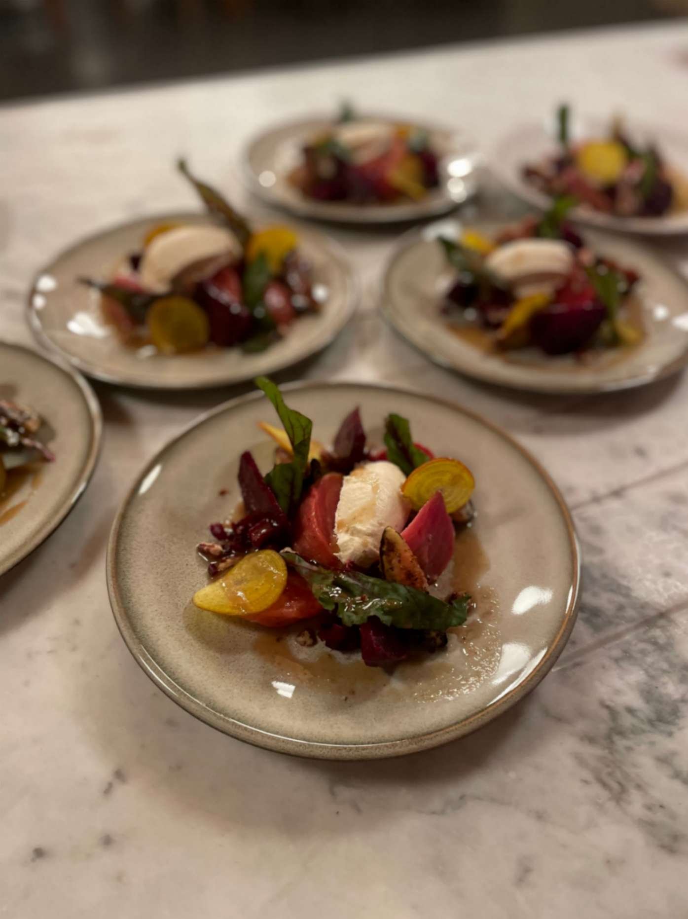  Colourful beetroot starter with leaves, nuts and creamy cheese.
