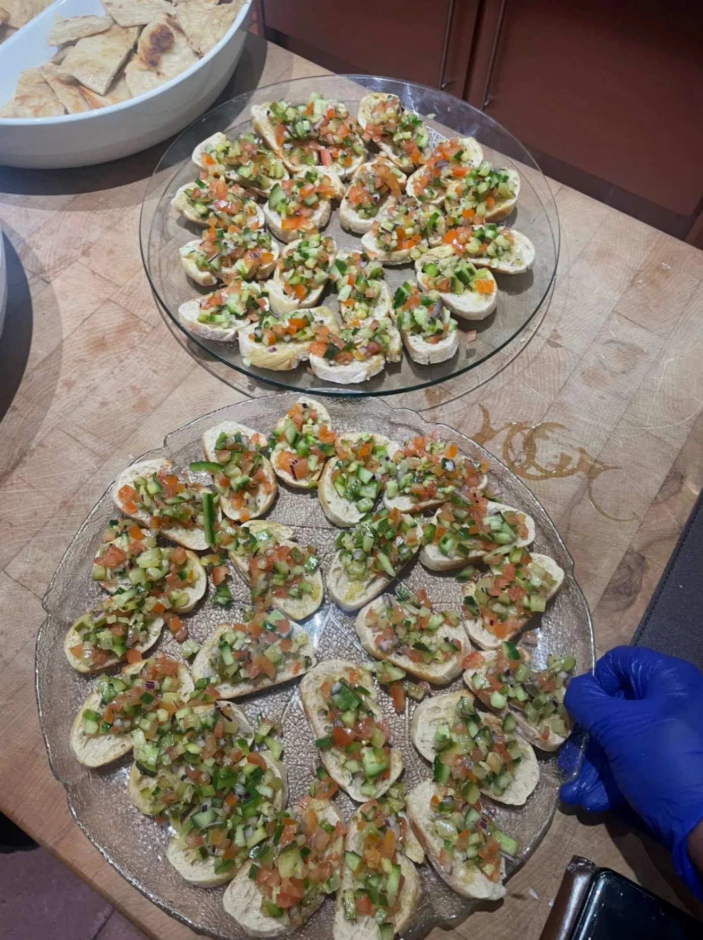 Platters of toasted bruschetta topped with chopped tomato, cucumber and fresh herbs.