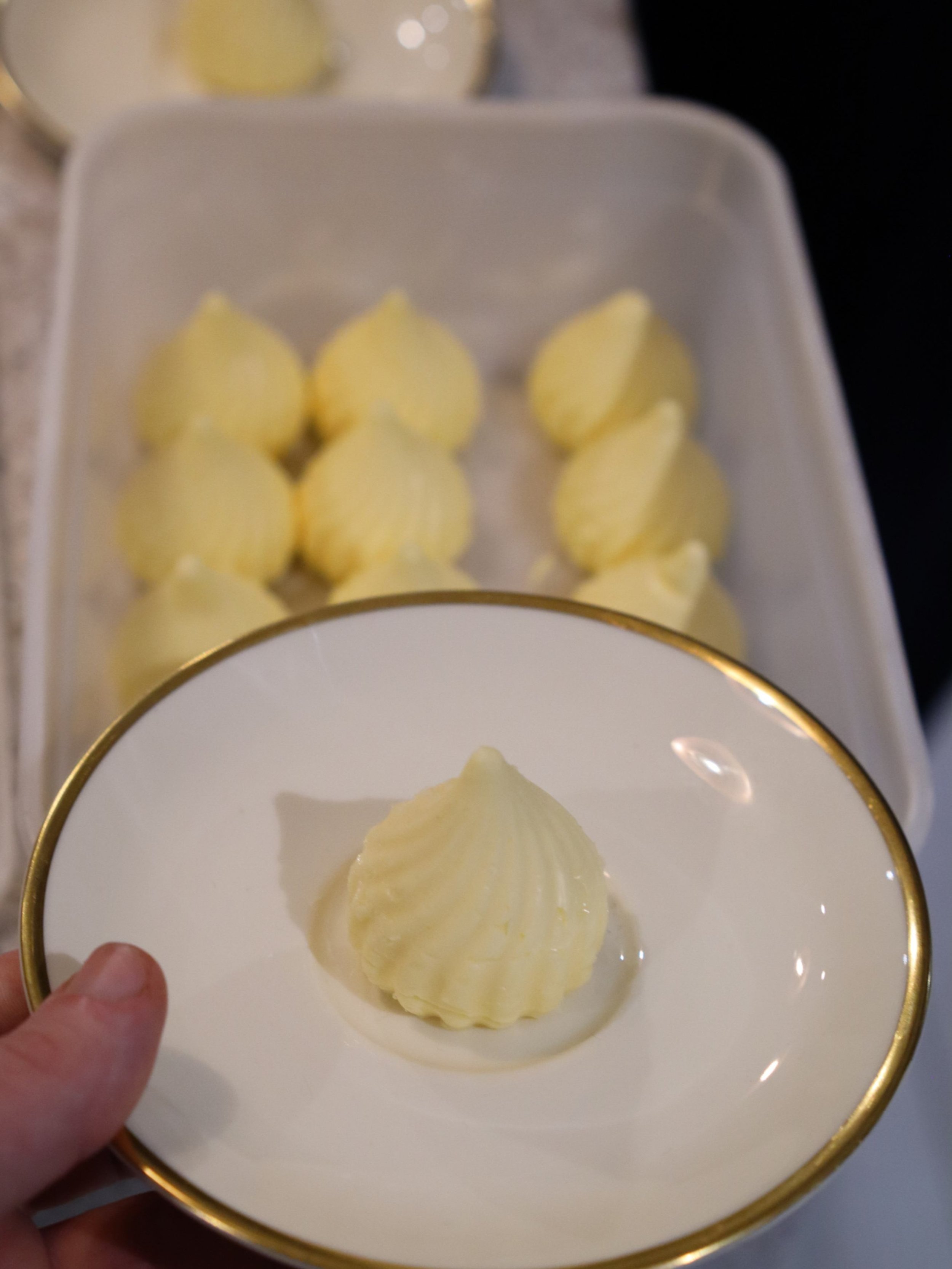 Individual piped butter portions prepared for private dining table service.