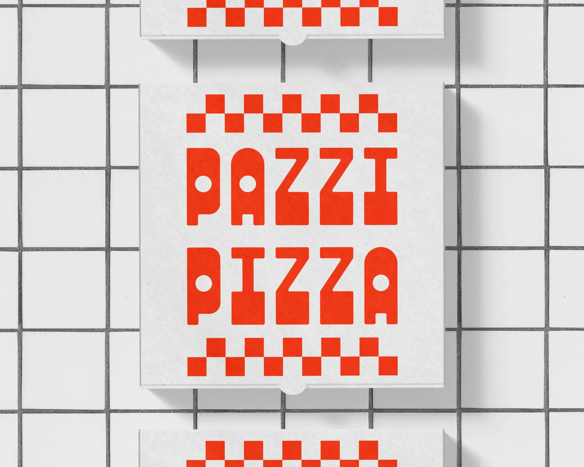 A stack of white pizza boxes with red checkered patterns and the words "PIZZA" printed in red on top. The boxes are placed on a tiled surface.