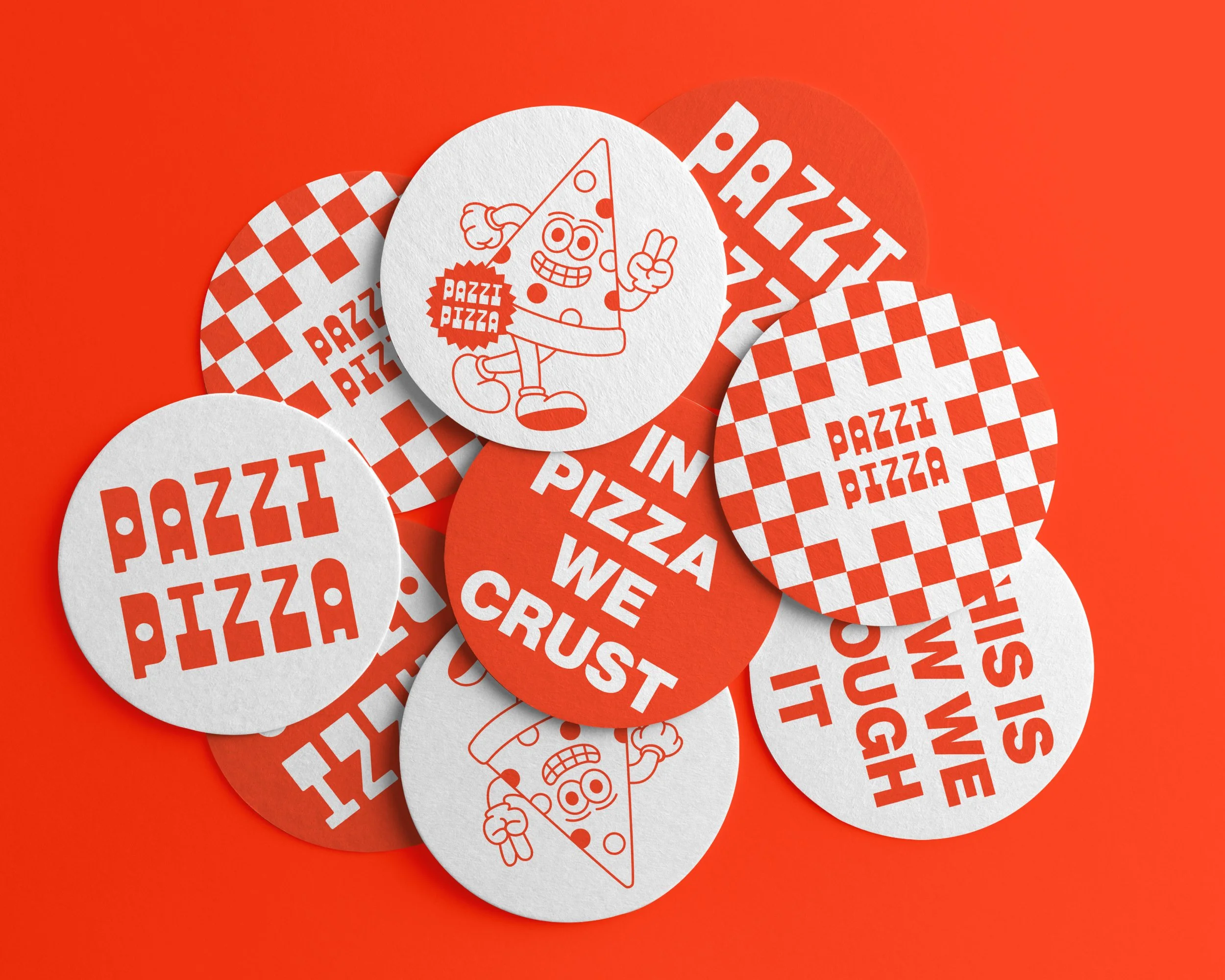 A pile of circular stickers with red and white patterns, featuring a cartoon pizza slice character and the words 'Pazzi Pizza' and 'We Crust' on an orange background.