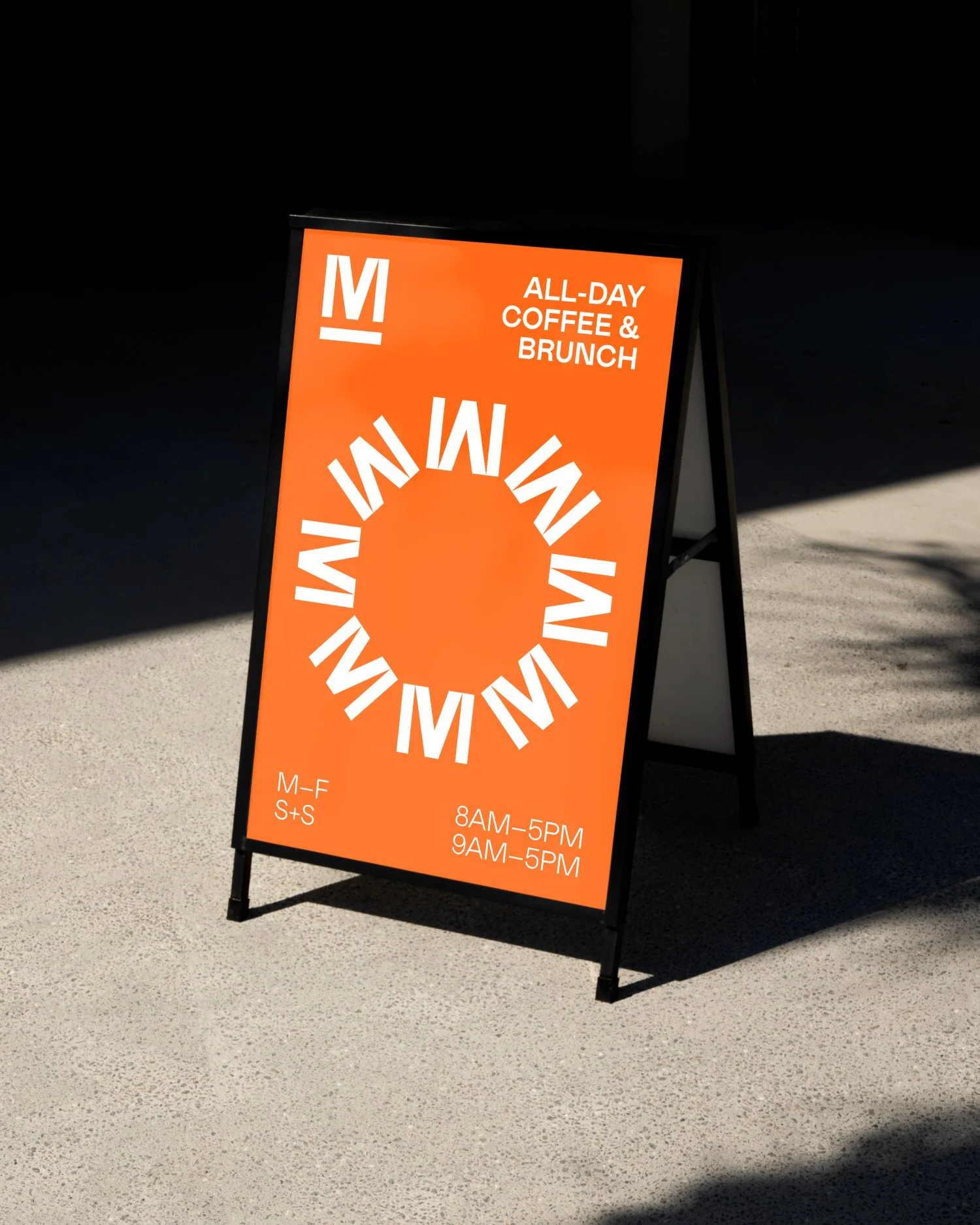 Orange sidewalk sign advertising all-day coffee and brunch, with the word 'WIMIN' in a circular pattern, and operating hours from 8 AM to 5 PM Monday through Friday.