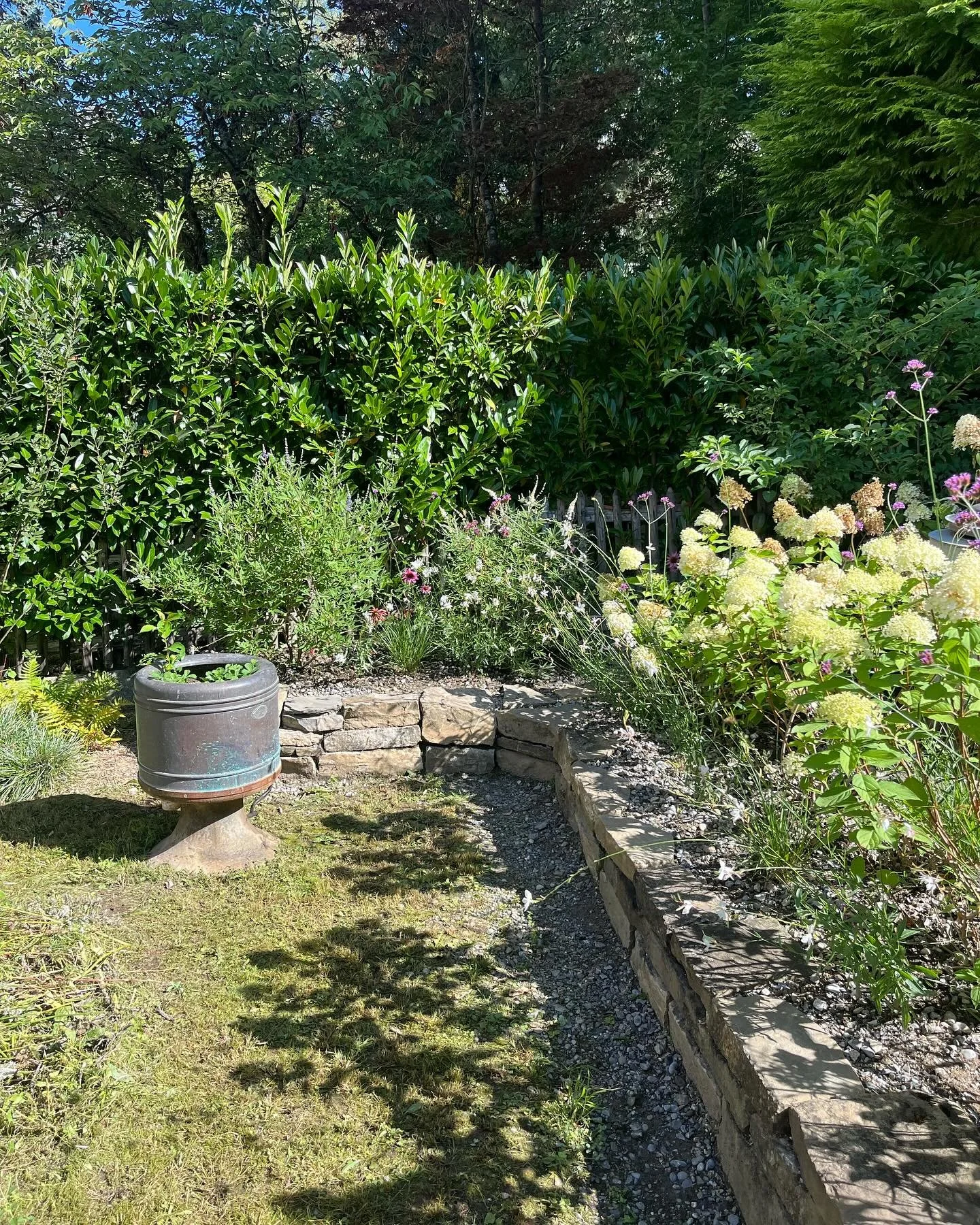 Mit viel Sorgfalt entstand hier eine kleine, naturnahe Oase: Die Trockenmauer aus Naturstein fügt sich harmonisch in den Garten ein und bietet Struktur sowie wertvollen Lebensraum für Insekten und Kleintiere. Die neue Bepflanzung ist verwur