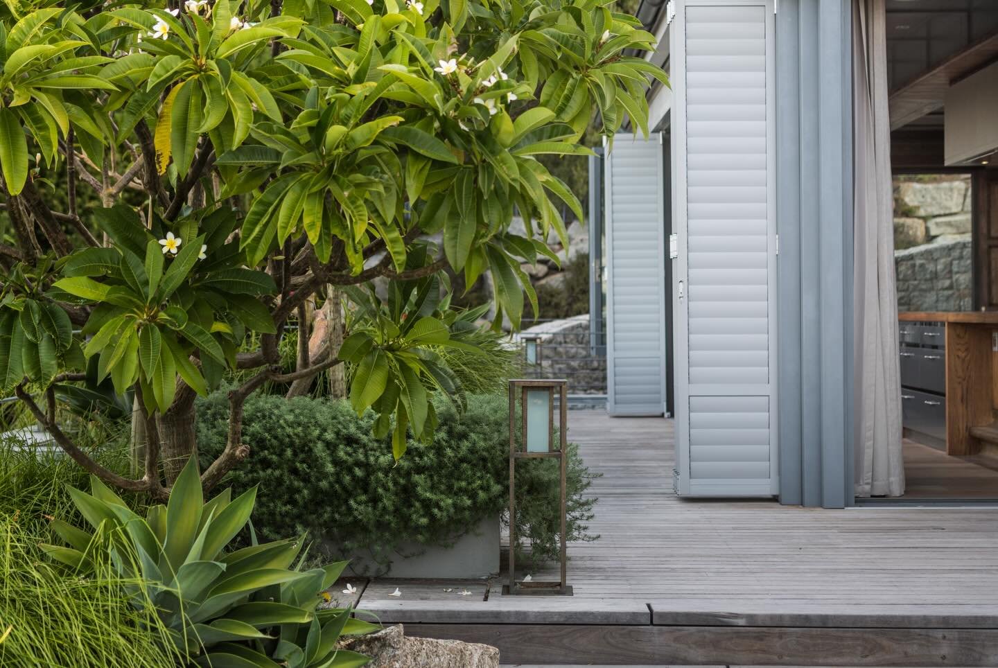 There is something special about a Cape summer. With shutters thrown wide and living spaces open to the elements, the garden becomes an extra room. We love how this custom brass lantern acts as a focal point against the raw timber, anchoring the view