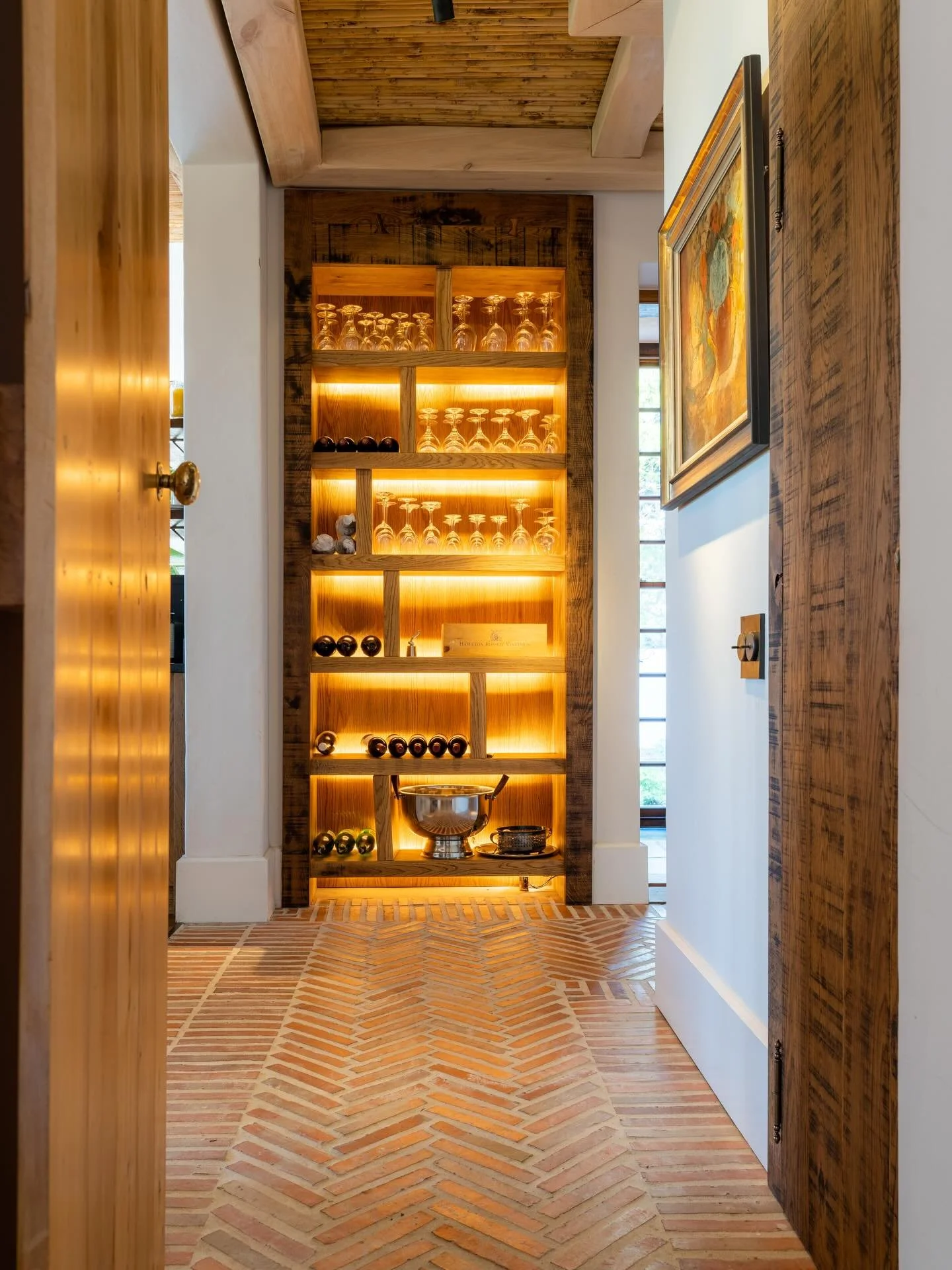 Our favourite shortcut in the house. Warm wood, soft glow, and rows of bottles that have seen a few good years. A small passage that carries its own kind of calm.