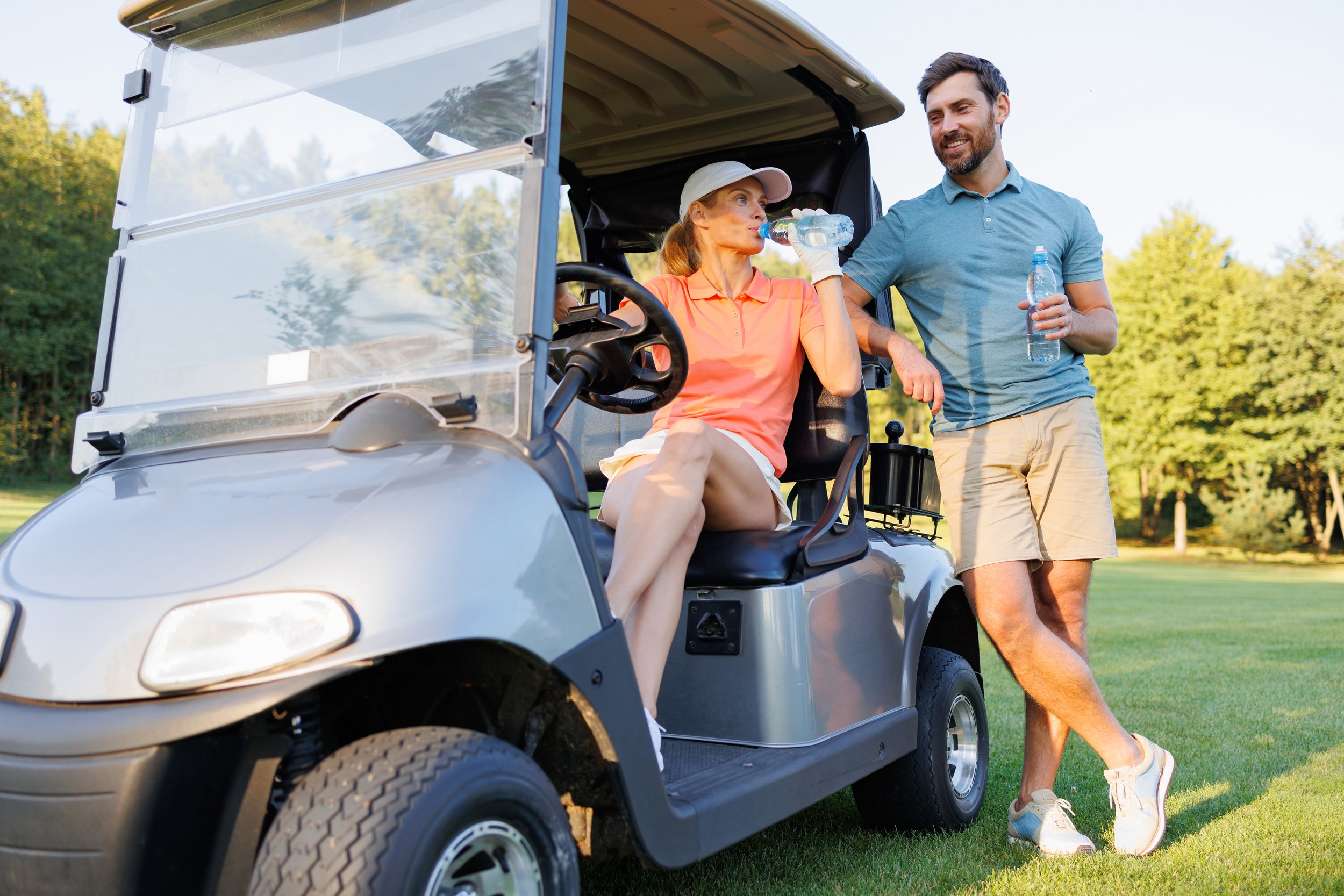 golfing-relaxation-couple-drinking-water-on-cart-2024-10-18-08-19-54-utc.jpg