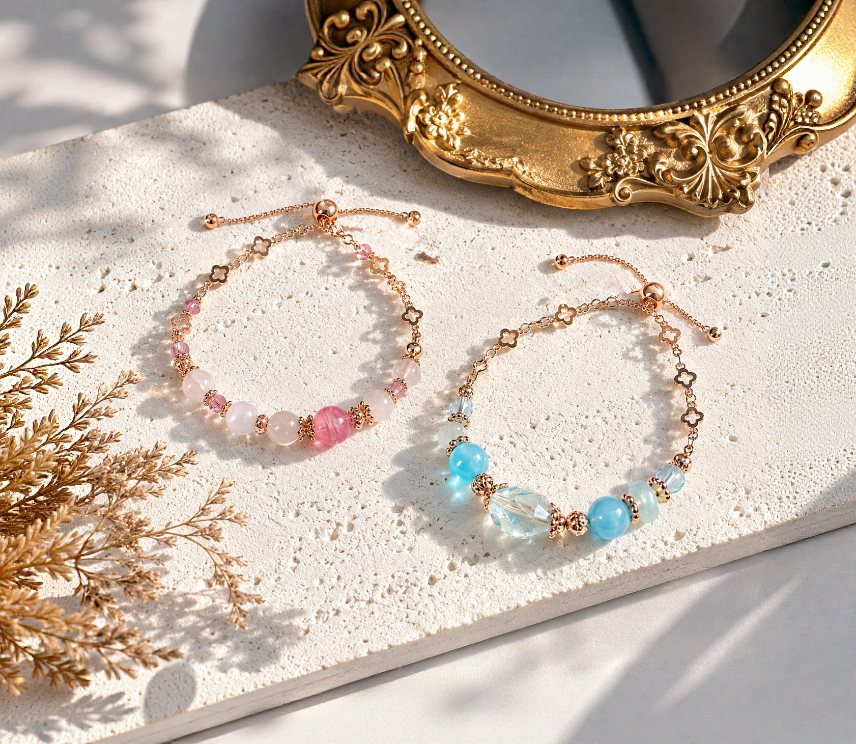 Close-up of colorful beaded necklaces with gold accents, placed on a textured white surface near an ornate gold mirror, with dried flowers nearby.