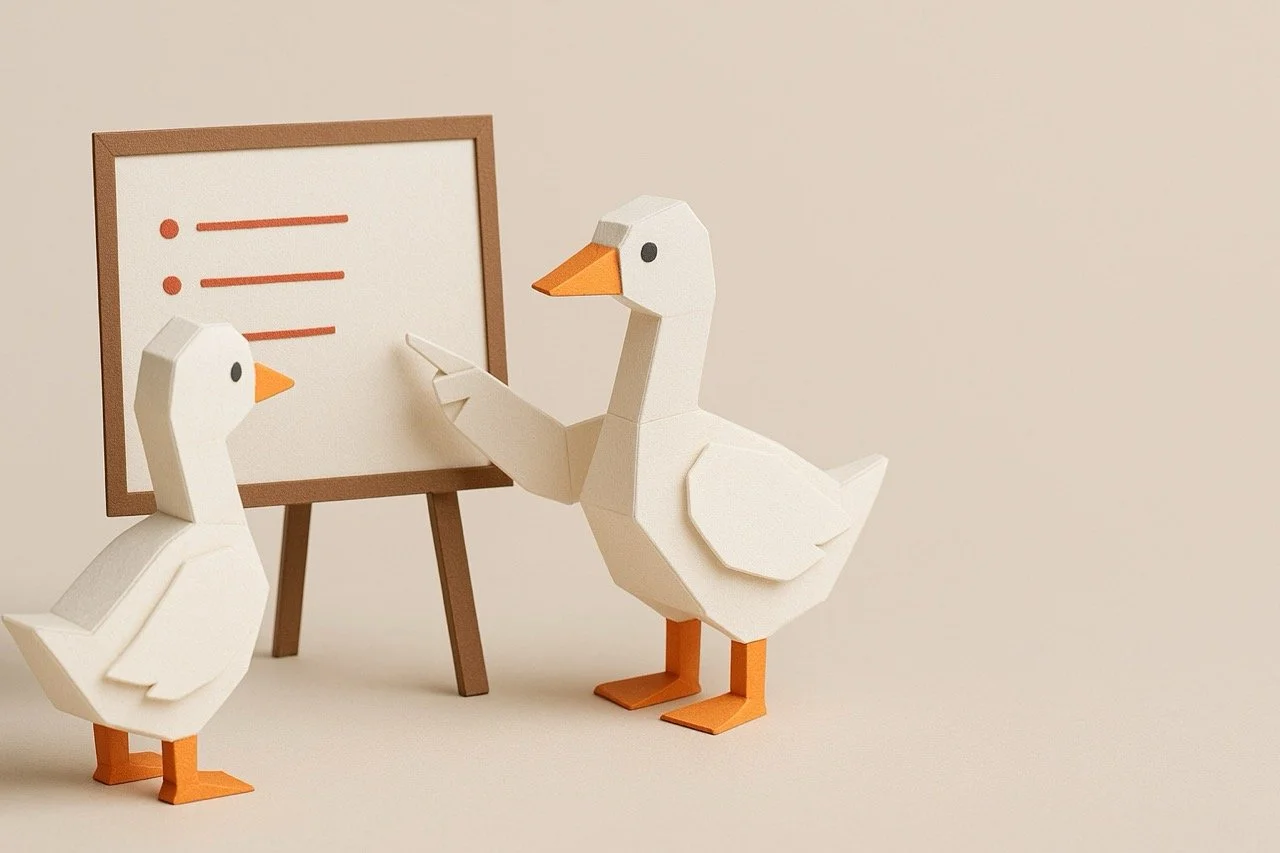 Twee papieren ganzen, één groter dan de ander, met oranje snavels en poten, staan voor een schoolbord met rode lijnen en stippen, op een beige achtergrond.