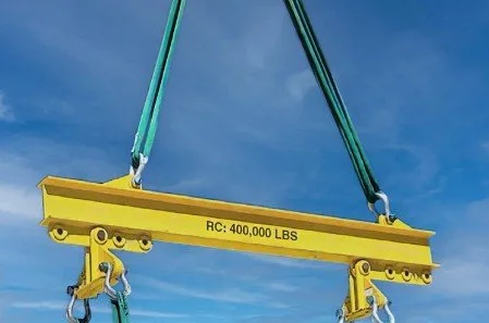 A large yellow lifting beam with the marking 'RC: 400,000 LBS' is suspended in the air against a blue sky.