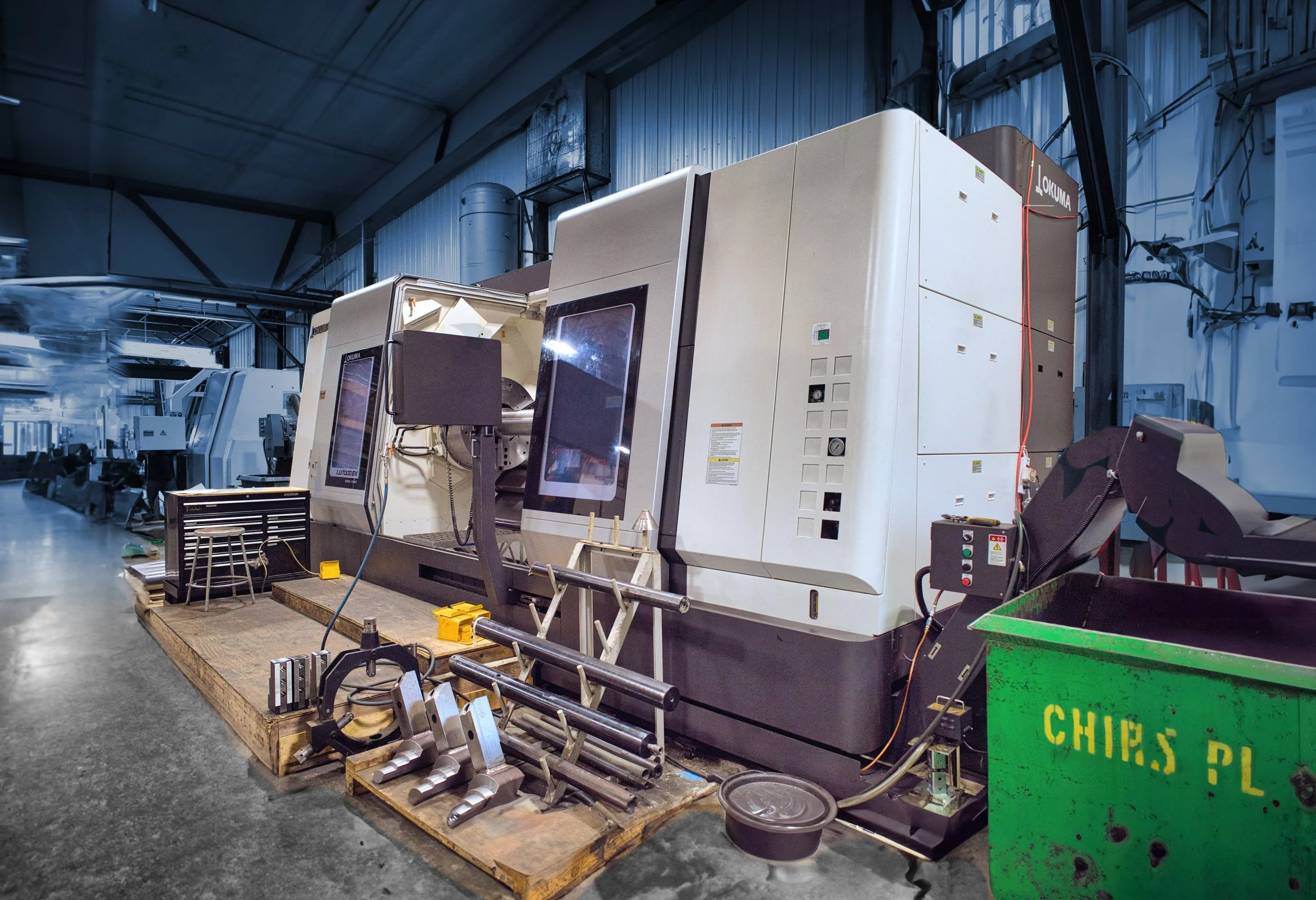 Industrial manufacturing machines in a factory setting with tools and equipment around