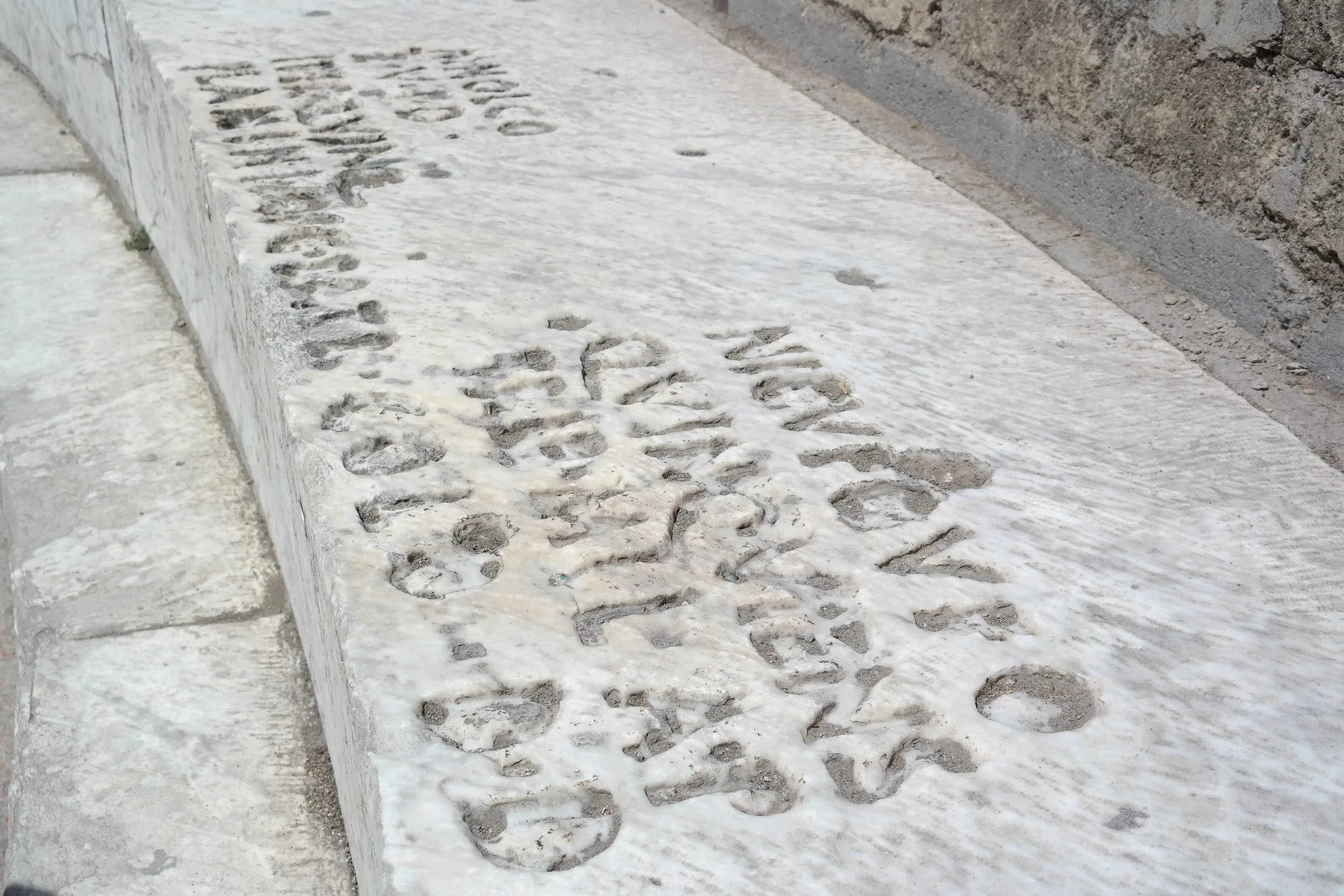 Fotografie von Polly Lohmann für die Novus Stiftung: Das römische Theater in Pompeji mit einer lateinischen Inschrift auf den Sitzstufen, gewidmet Marcus Holconius Rufus und Marcus Holconius Celer (1. Jahrhundert n. Chr.).