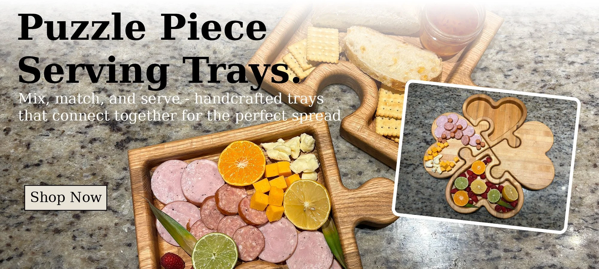 Photo of wooden puzzle piece serving trays on a granite countertop, with one tray filled with assorted meats, cheeses, and citrus slices, and a smaller tray with a decorated puzzle piece of cookies and candies.
