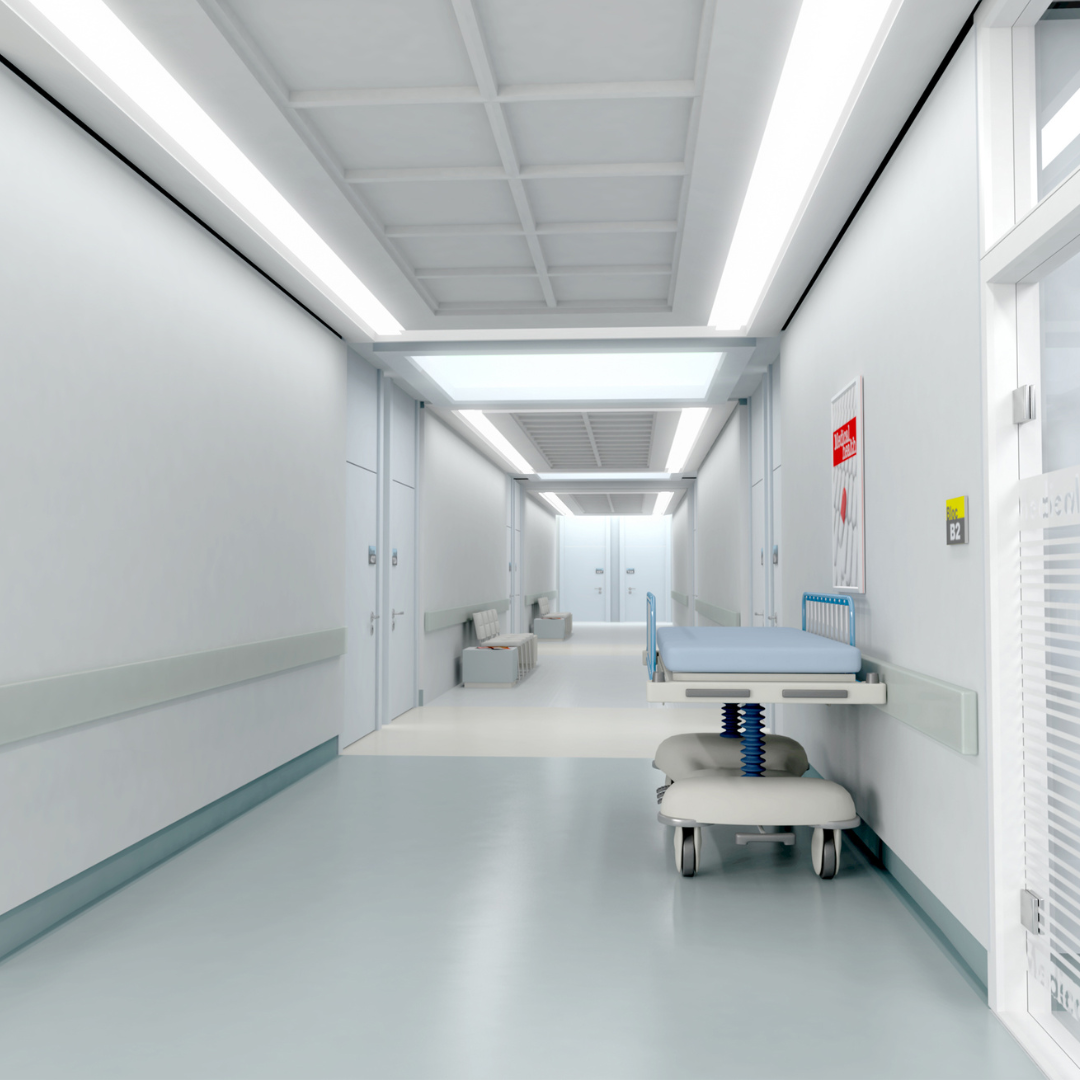 Pasillo en un hospital con una camilla, sillas y señalización de emergencias.