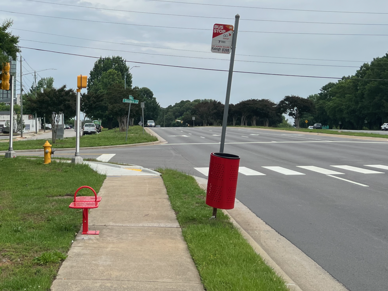 Photograph of a bus stop at Saunders without any shade or shelter.