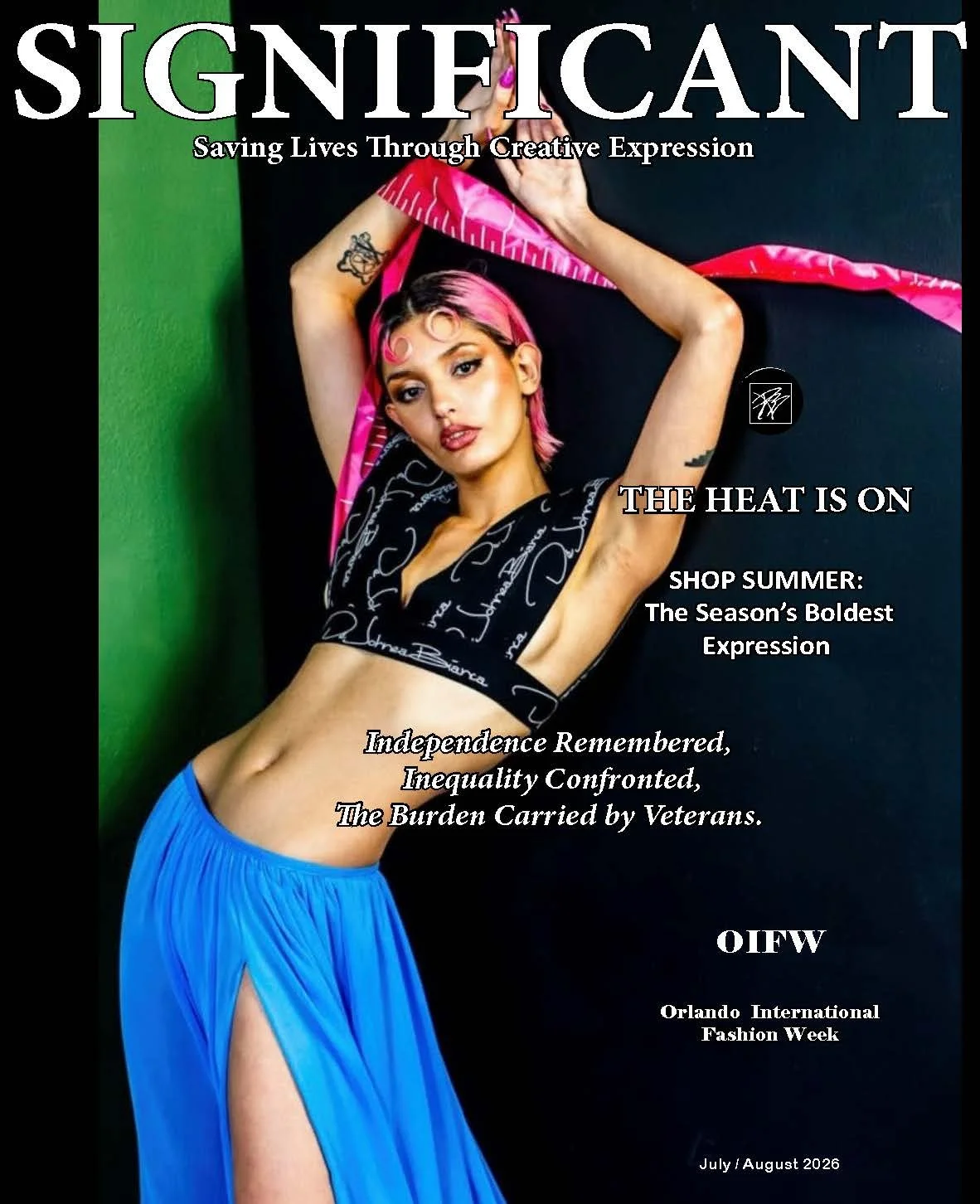 A magazine cover featuring a woman with pink hair, tattoos, wearing a black signature-pattern crop top and a flowing blue skirt with a slit. She poses against a black and green background, with text about fashion, independence, and veterans.