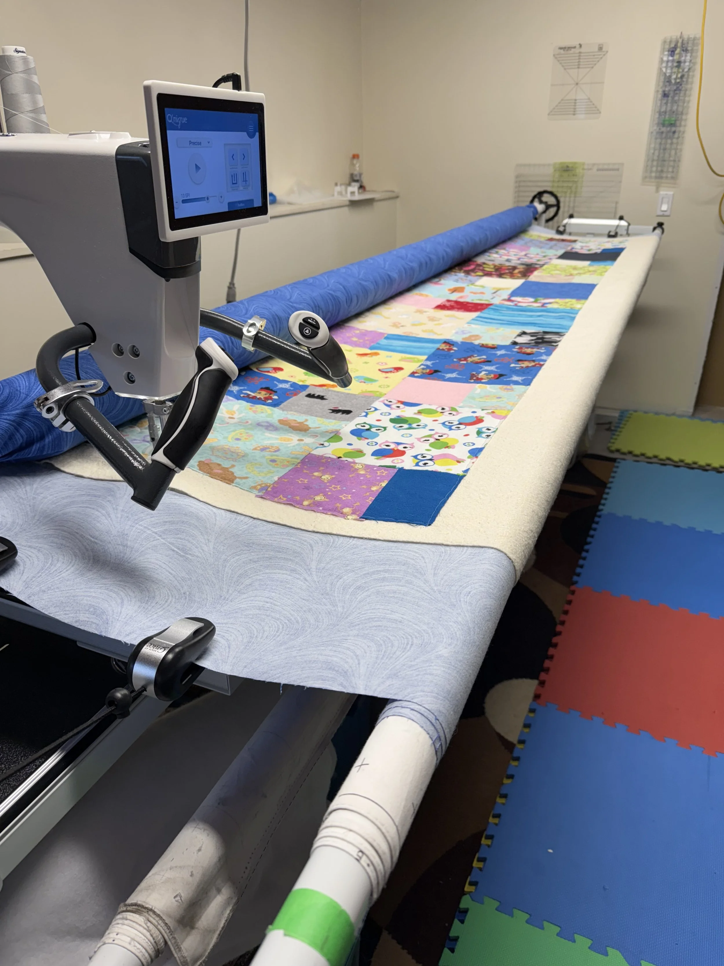 A client's quilt is part-way done on the long arm quilting frame.