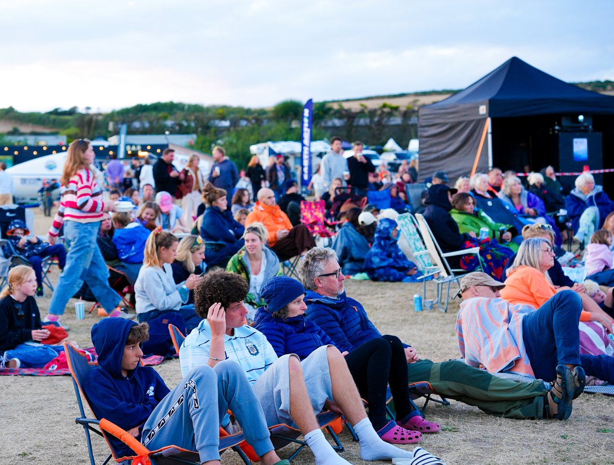 Photo of attendees, sitting on camping chairs, watching the films