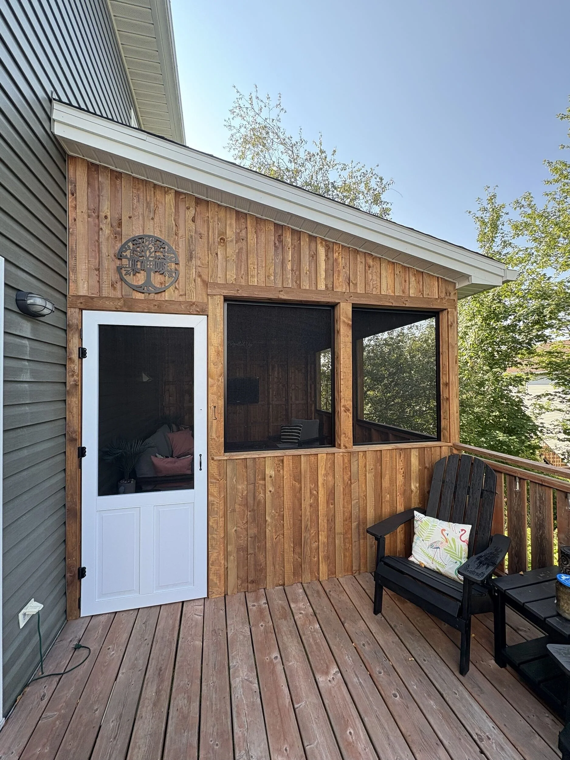 Exterior view of The Treehouse, a custom elevated screened deck addition built above a walkout basement in Halifax, Nova Scotia.