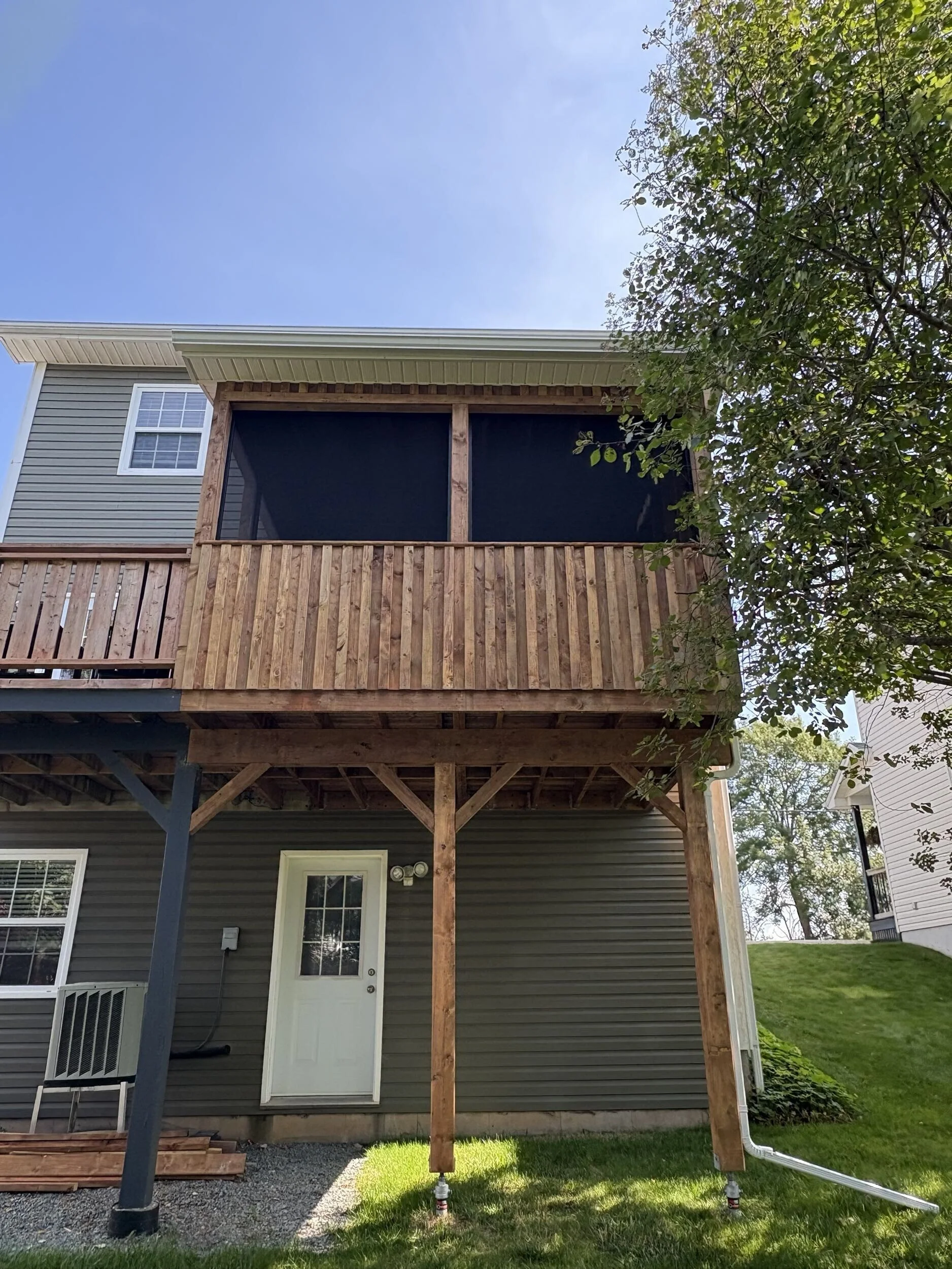 Exterior view of The Treehouse, a custom elevated screened deck addition built above a walkout basement in Halifax, Nova Scotia.