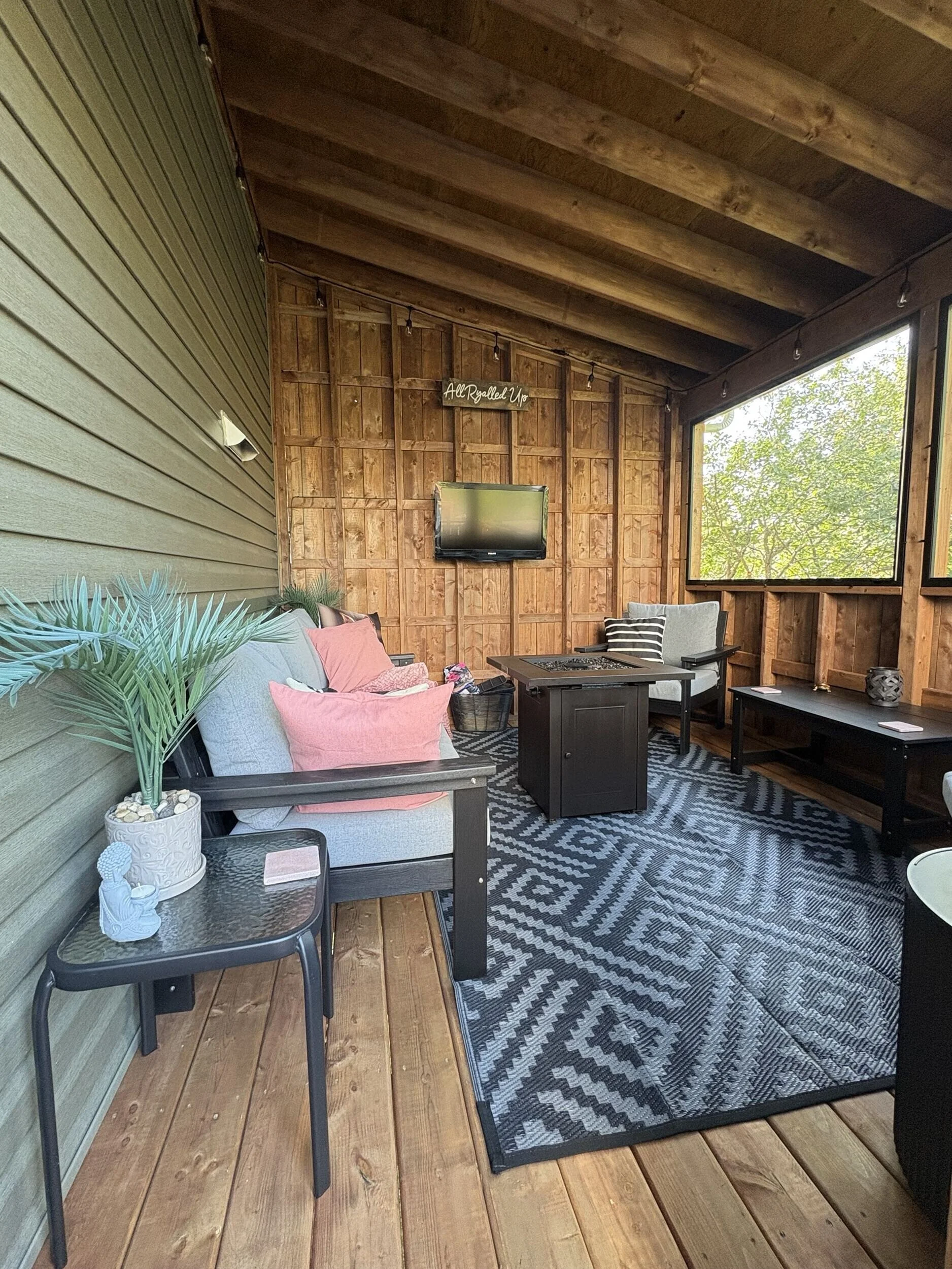 Interior of The Treehouse featuring natural wood finishes, screened openings, and comfortable seating for year-round outdoor living and entertaining.