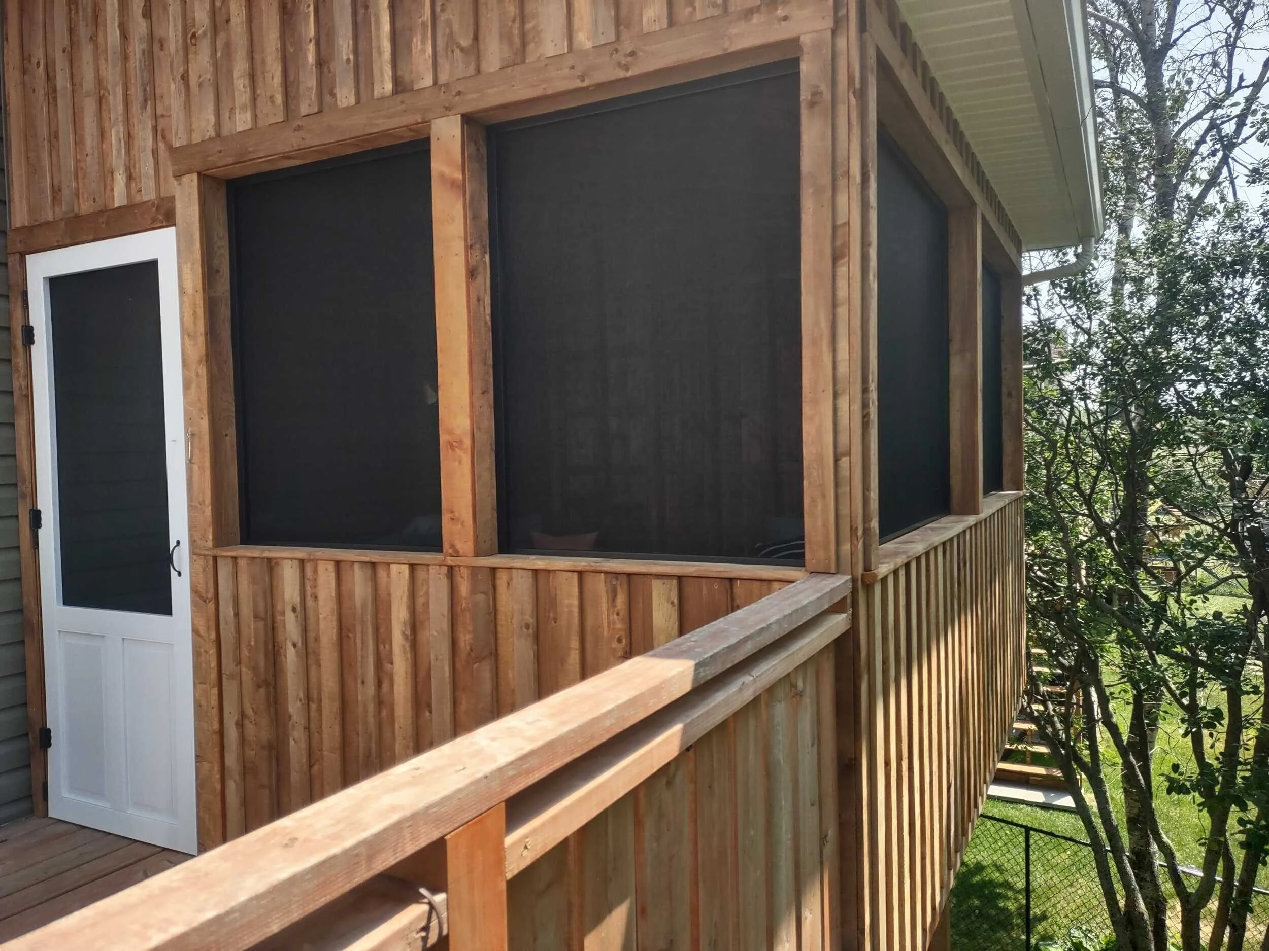 Exterior view of The Treehouse, a custom elevated screened deck addition built above a walkout basement in Halifax, Nova Scotia.